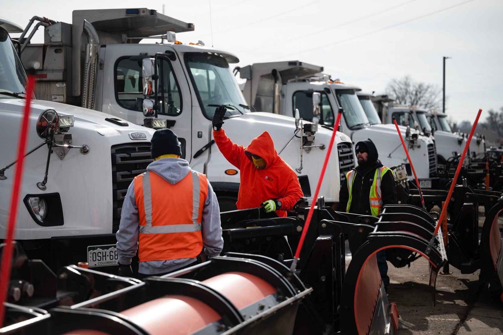 Street maintenance crew member Polo Ramirez gives a signal to equipment operator specialist George Lopez in the cab of the plow while demonstrating how to disconnect and reconnect a large plow on Tuesday, Jan. 17, 2023, at Denver’s Central Platte Campus in Denver, Colo.(Timothy Hurst/The Denver Gazette) (TIMOTHY HURST/DENVER GAZETTE)