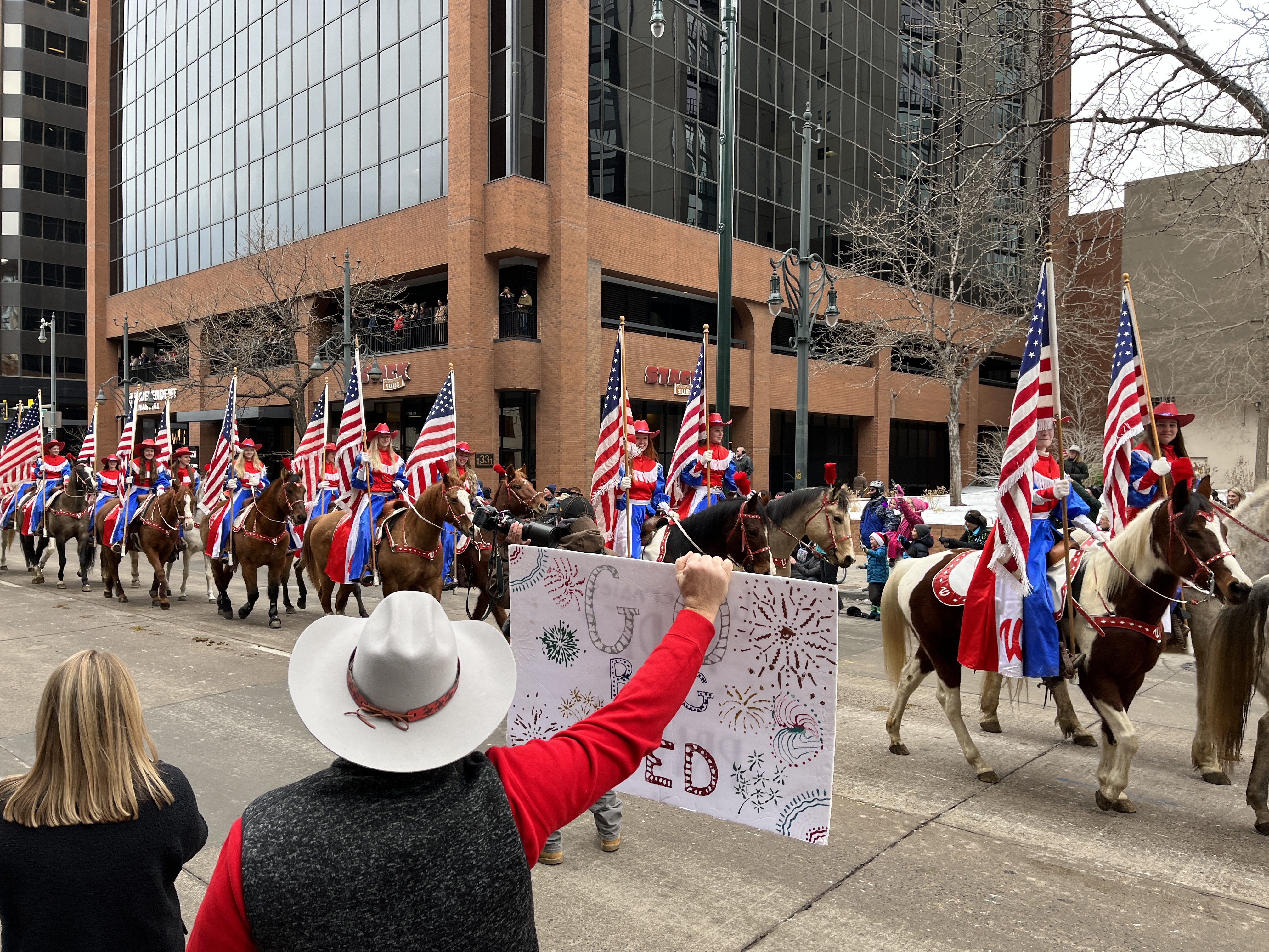Jeff Blatt cheers on the Westernaires as they march in the National Western Stock Show Parade on Jan. 5, 2023. His daughter, who is a Westernaire but could not attend the parade, made the sign for friends who took part in the parade (Alex Edwards/The Denver Gazette)