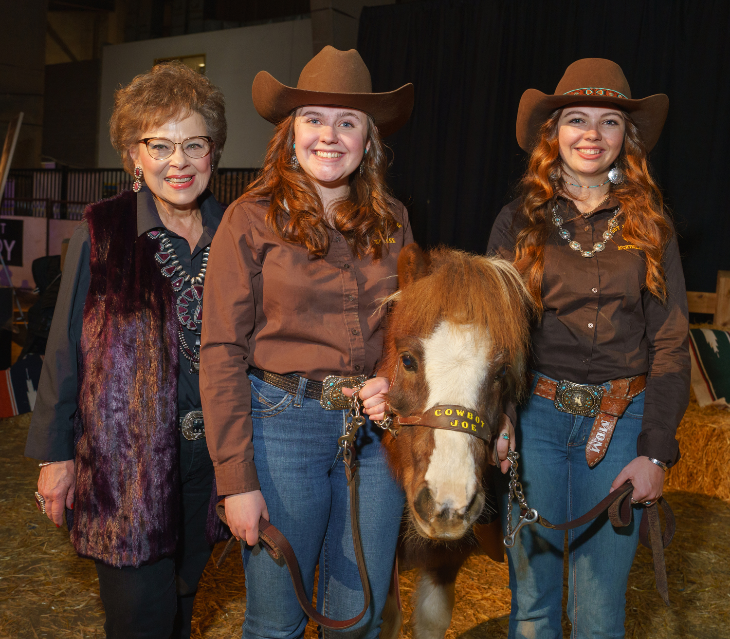 Teema McIntosh, left, living near Windsor, Colorado, with Cowboy Joe handlers Kaylee Davis, and McKinley Muhlbauer. The Farthing family, beginning with McIntosh’s great-grandfather, Charles, have donated the five “Cowboy Joe” University of Wyoming mascots from their ranch near Cheyenne Wyoming, ever since 1950. The National Western Stock Show 2023 Citizen of the West award dinner at the National Western Events Center in Denver, Colorado, on Monday, Jan. 9, 2023. Photo StevePeterson.photo (STEVE PETERSON/SPECIAL TO THE DENVER GAZETTE)