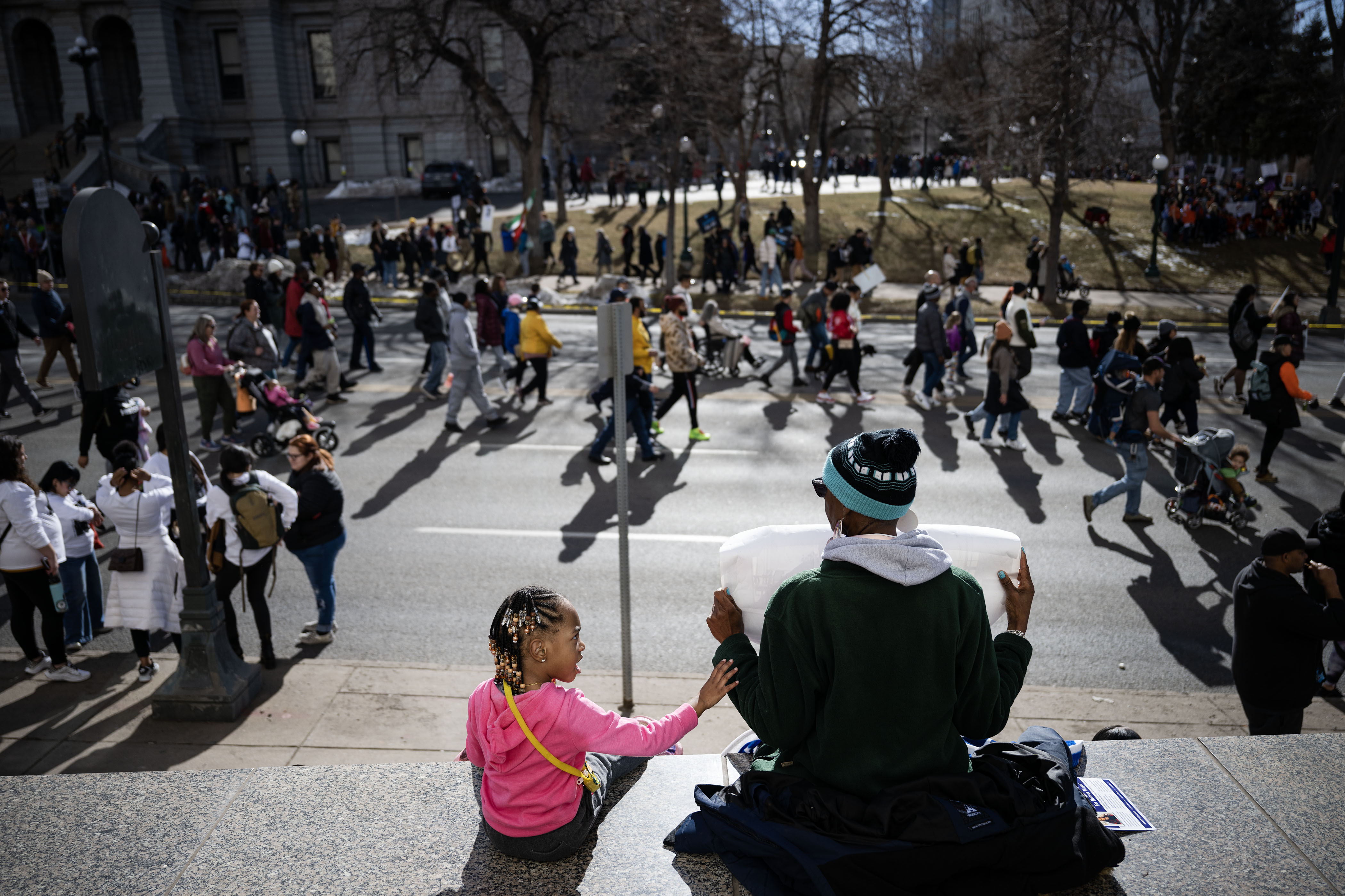 Amira Guilford, 4, taps her grandmother, Sandra Guilford, on the arm as Denver's annual Martin Luther King Jr. Day marade makes its way past on East Colfax Avenue on Monday, Jan. 16, 2023, in Denver, Colo.(Timothy Hurst/The Denver Gazette) (TimHursttim.hurst@gazette.comhttps://secure.gravatar.com/avatar/aca82bd62b4ee425c598527cd6faa1b1?d=mm&r=g)