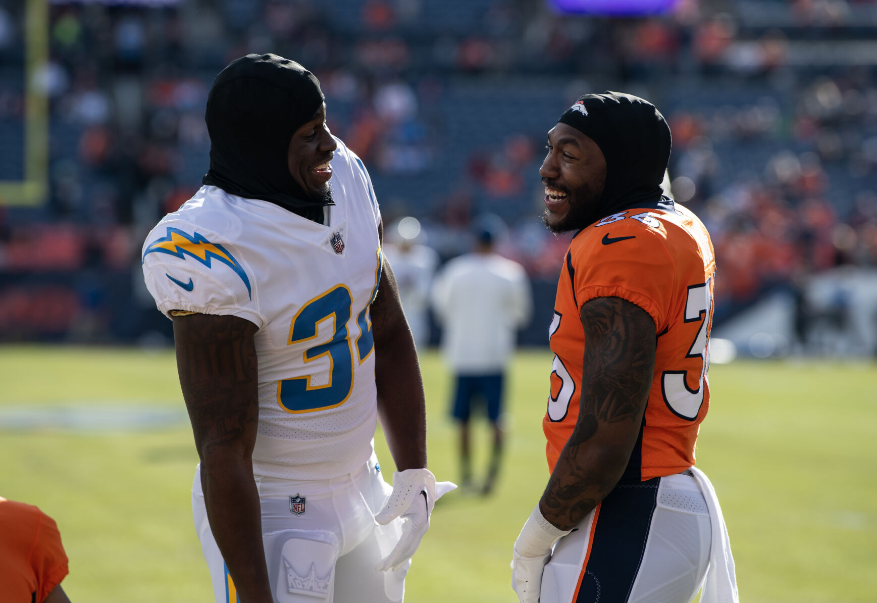 Denver Broncos running back Tyler Badie (36) and Los Angeles Chargers safety Nasir Adderley (24) joke around before the last regular season game Sunday, Jan. 8, 2023 at Empower Field at Mile High in Denver. (Parker Seibold, The Gazette) (Parker Seibold)