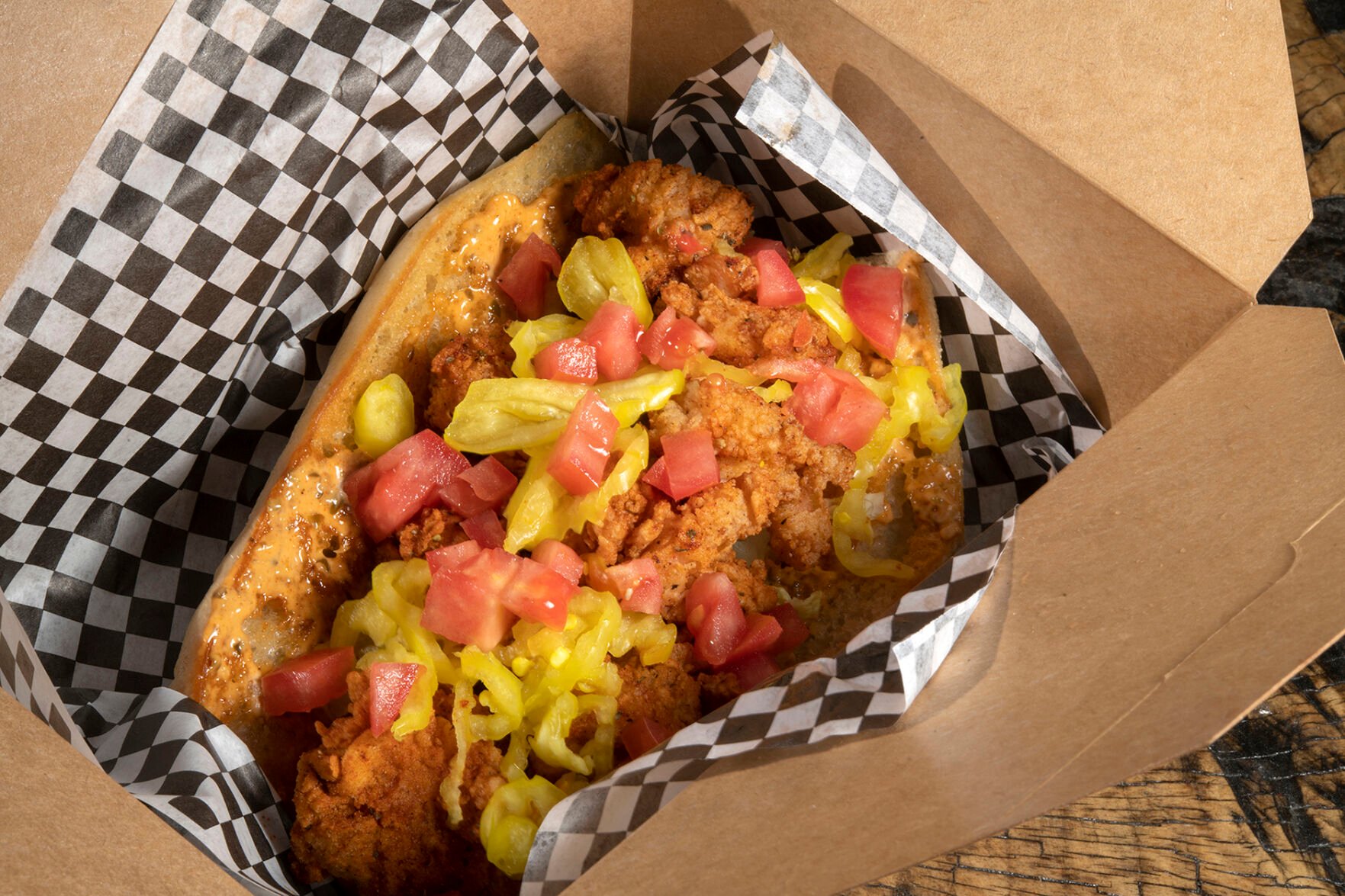 Shrimp po’boy at Po’Brothers. The toasted roll is coated with house-made remoulade and overflows with crusty breaded shrimp, diced tomato and strips of banana pepper. (Jeff Kearney)
