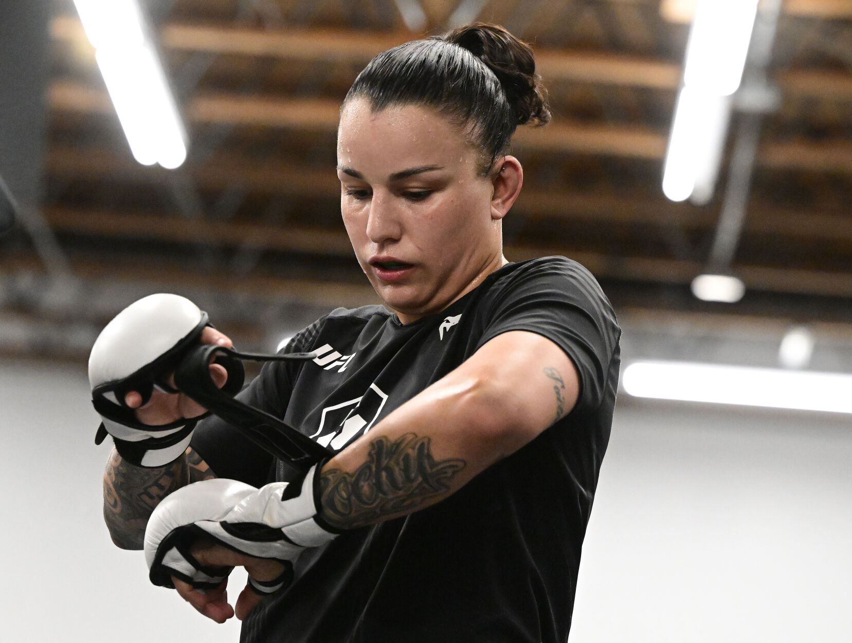 UFC fighter Raquel Pennington puts on her gloves before practice on Monday, Jan. 9, 2023. Pennington went to Harrison High School and still lives in Colorado Springs. She is ranked #5 in the world and will fight Ketlen Vieira, who is ranked #2, on Saturday night in Las Vegas. (Photo by Jerilee Bennett, The Gazette)