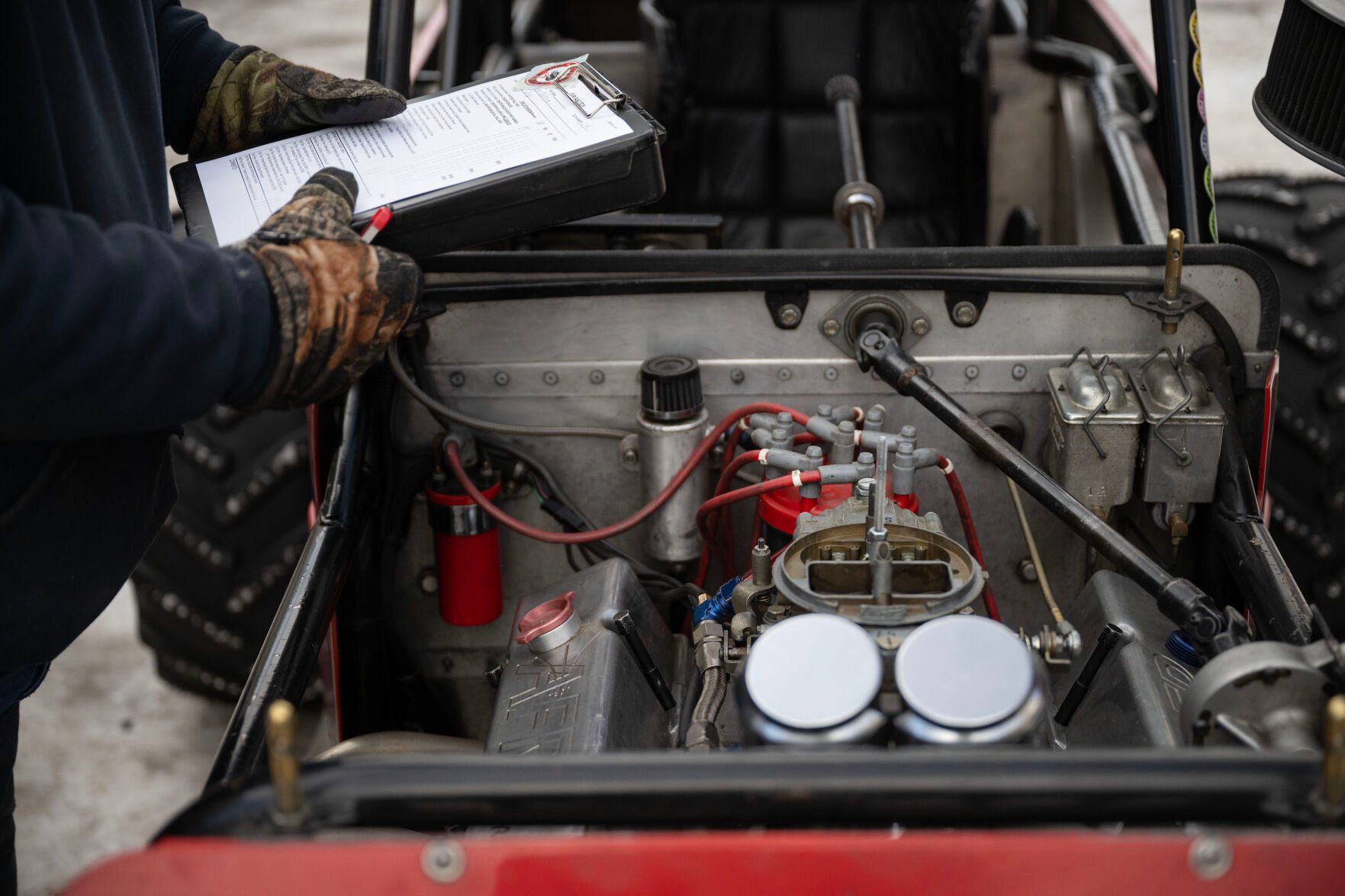 Joe Huffaker inspects Lee Bashline’s highly modified single-seater Willys Jeep CJ-3A during the first day of the Our Gang 4 Wheelers ice racing club’s 2023 racing season on Saturday, Jan. 7, 2023, in Georgetown. (Timothy Hurst, The Gazette)
