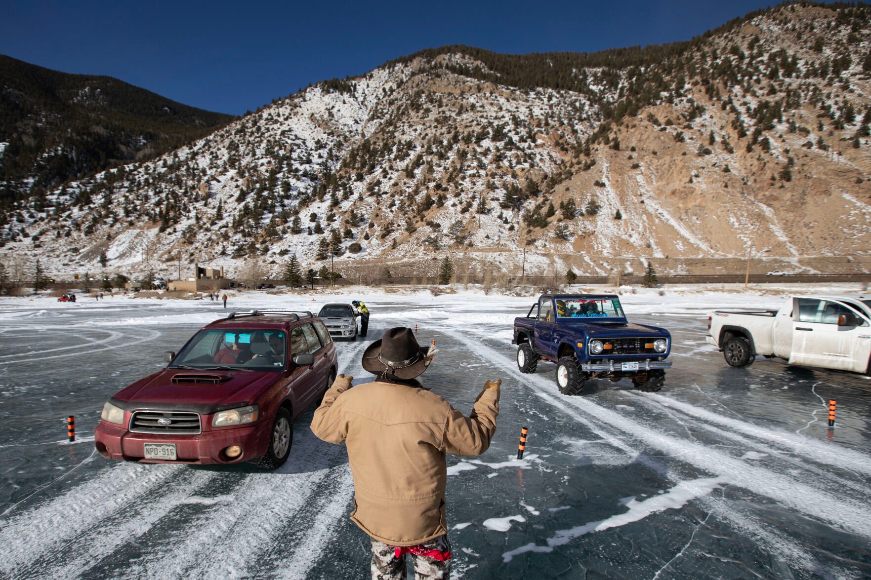 JR Davis waves cars out to the track during the first day of the Our Gang 4 Wheelers ice racing club’s 2023 racing season on Saturday, Jan. 7, 2023, in Georgetown. (Timothy Hurst, The Gazette)