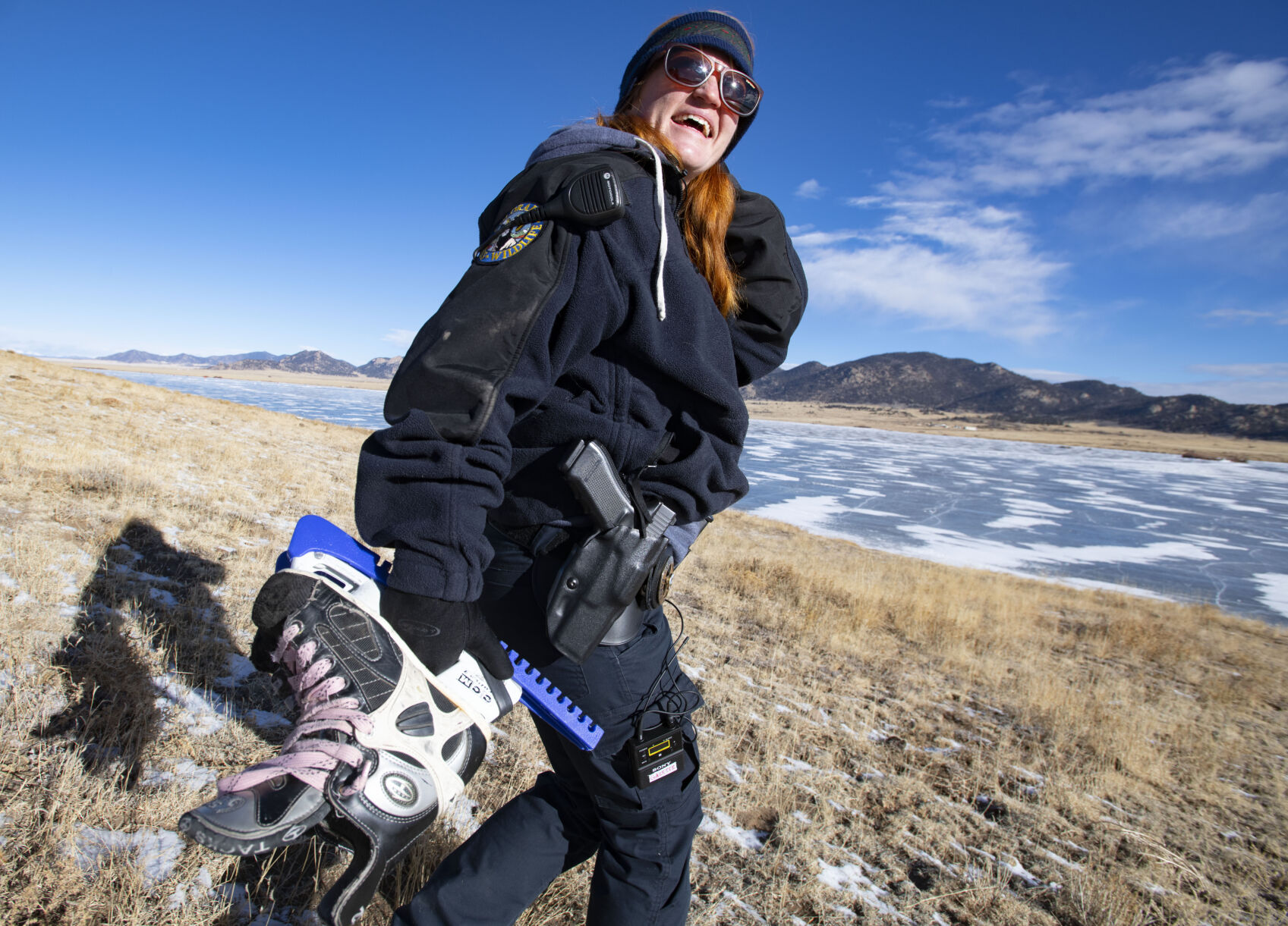 Colorado Parks and Wildlife Ranger Kelli Lewis carries her ice skates with her as she walks down to Eleven Mile Reservoir to patrol early this month. Lewis started skating on the ice last year when a warm winter made the ice unsafe to patrol on a snowmobile. (Christian Murdock, The DENVER Gazette)