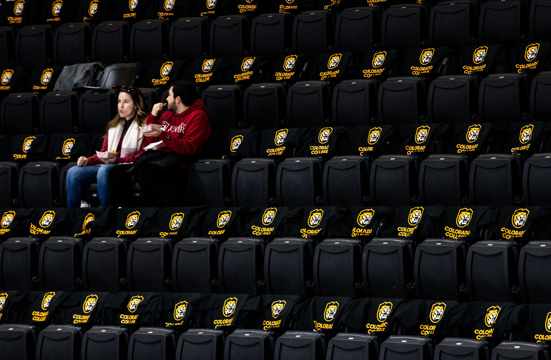 Seats covered in Colorado College t-shirts surround two hockey fans that arrive at Ed Robson Arena early on Saturday, Feb. 4, 2023. (Parker Seibold, The Gazette) (Parker Seibold)