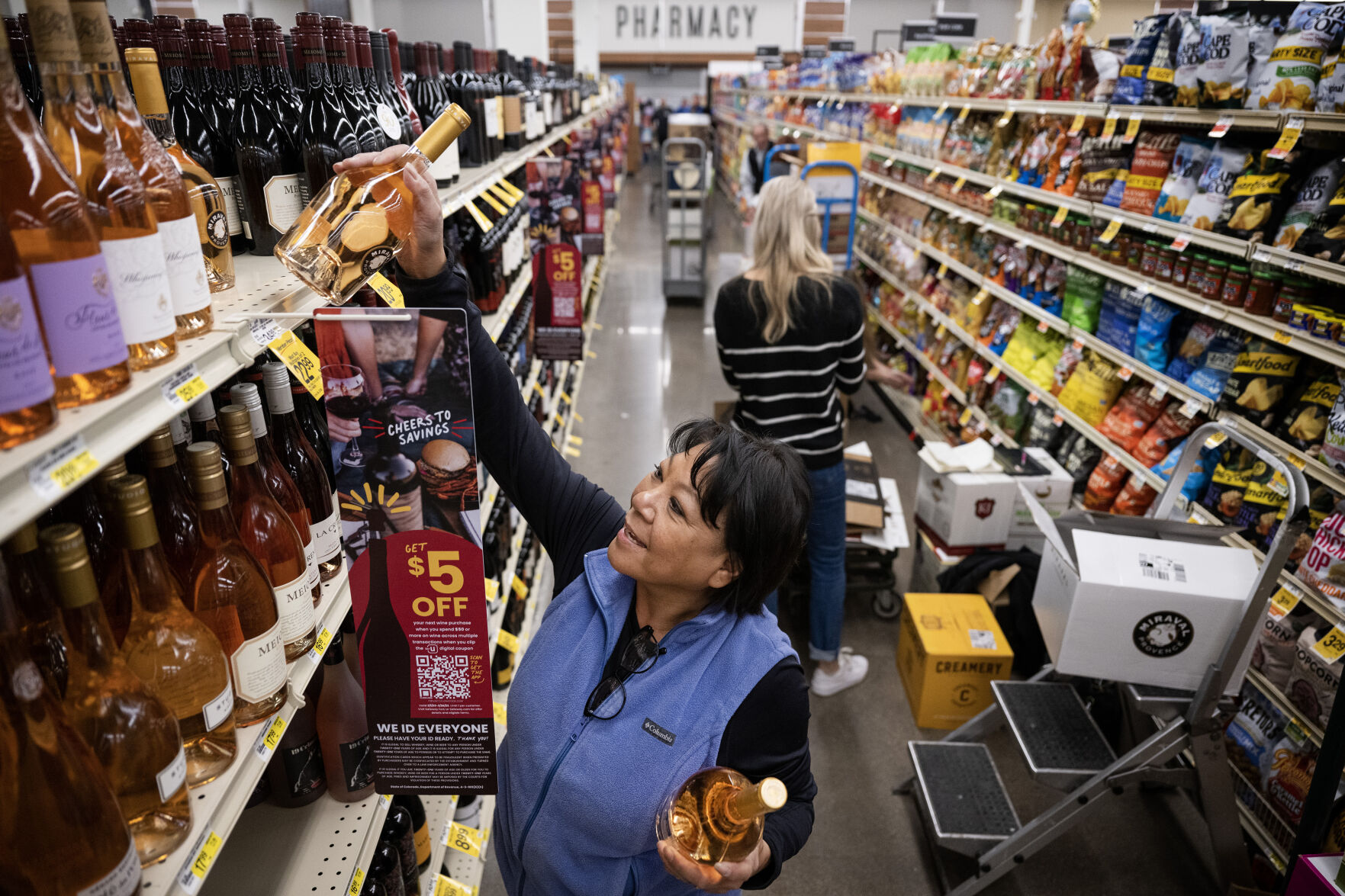 SAS Retail Services merchandising lead Melody Mae stocks bottles of Chateau Miraval Cotes de Provence Rose on the top shelf of aisle three on Wednesday, March 1, 2023, at the Safeway grocery store on South Havana Street in Aurora, Colo. (Timothy Hurst/Denver Gazette) (Timothy Hurst/Denver Gazette)