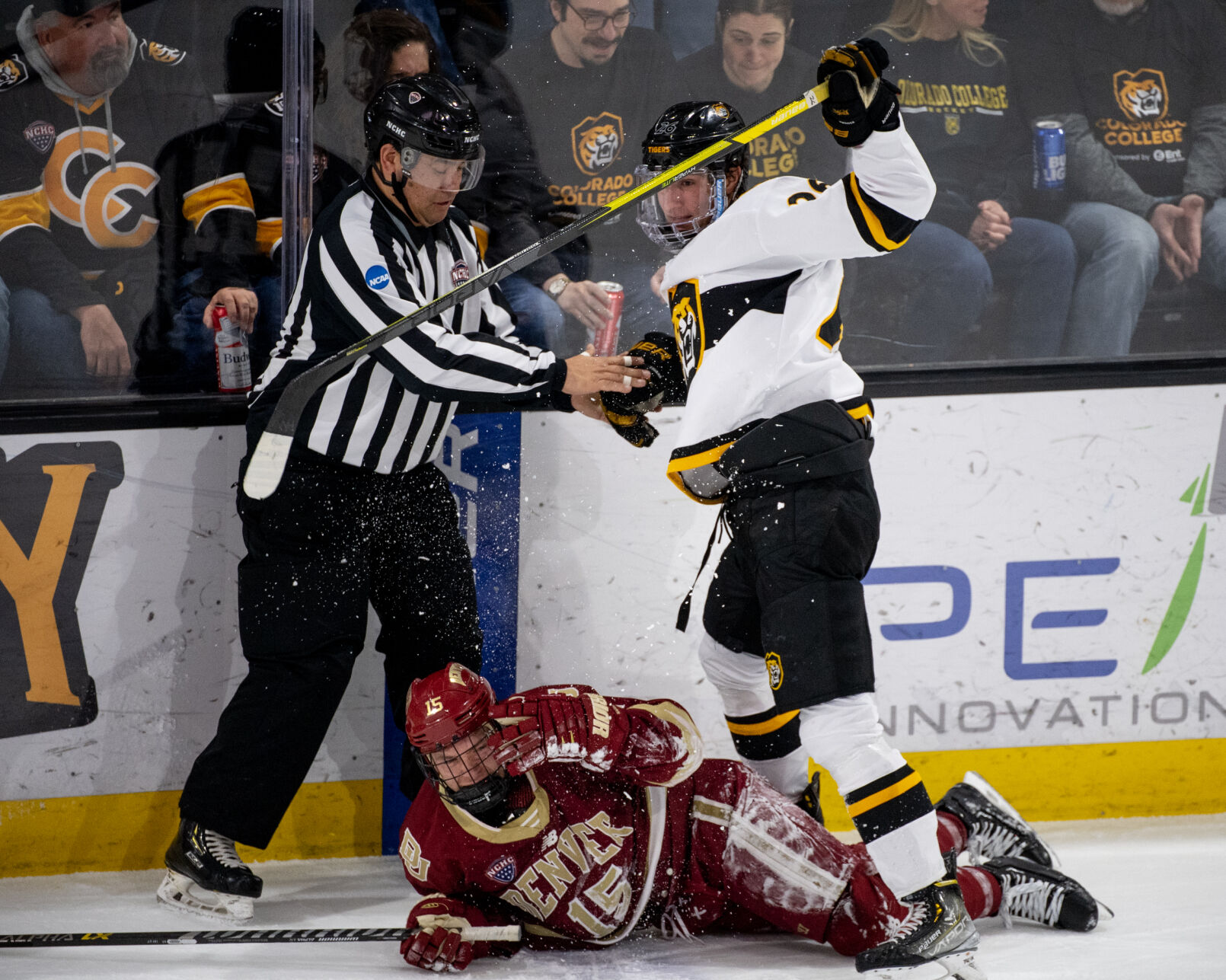 A referee helps Colorado College forward Noah Laba (26) stand up after a collision with Denver forward Carter King (15) in the second period of a hockey game on Saturday, Feb. 4, 2023, at Ed Robson Arena in Colorado Springs, Colo. (Parker Seibold, The Gazette) (Parker Seibold)