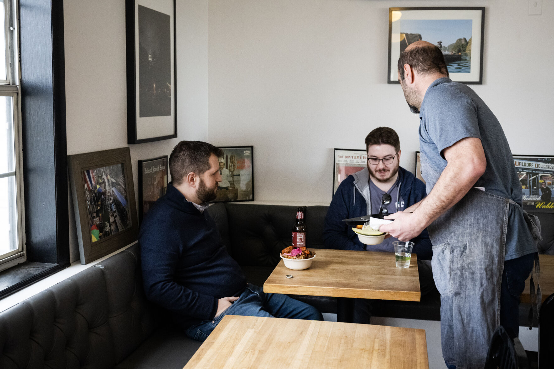 Owner and operator Steve Shander, who runs the restaurant with his wife Tina Shander, delivers orders to customers Geoff Bulson, left, and Sean Cushman just after opening on Thursday morning, Feb. 9, 2023, at Latke Love in Littleton, Colo.(Timothy Hurst/The Denver Gazette) (TimHursttim.hurst@gazette.comhttps://secure.gravatar.com/avatar/aca82bd62b4ee425c598527cd6faa1b1?d=mm&r=g)