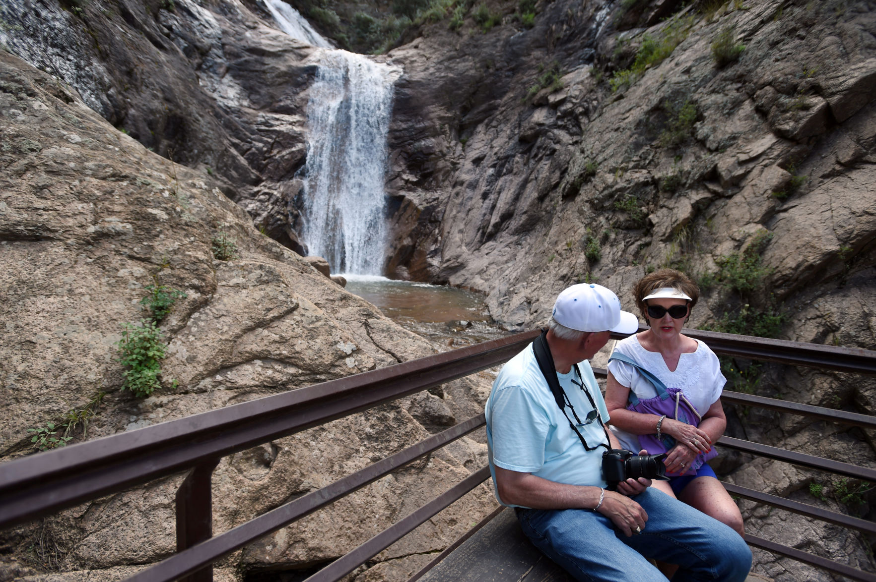 A couple takes a seat at the base of Seven Falls. (Jerilee Bennett)