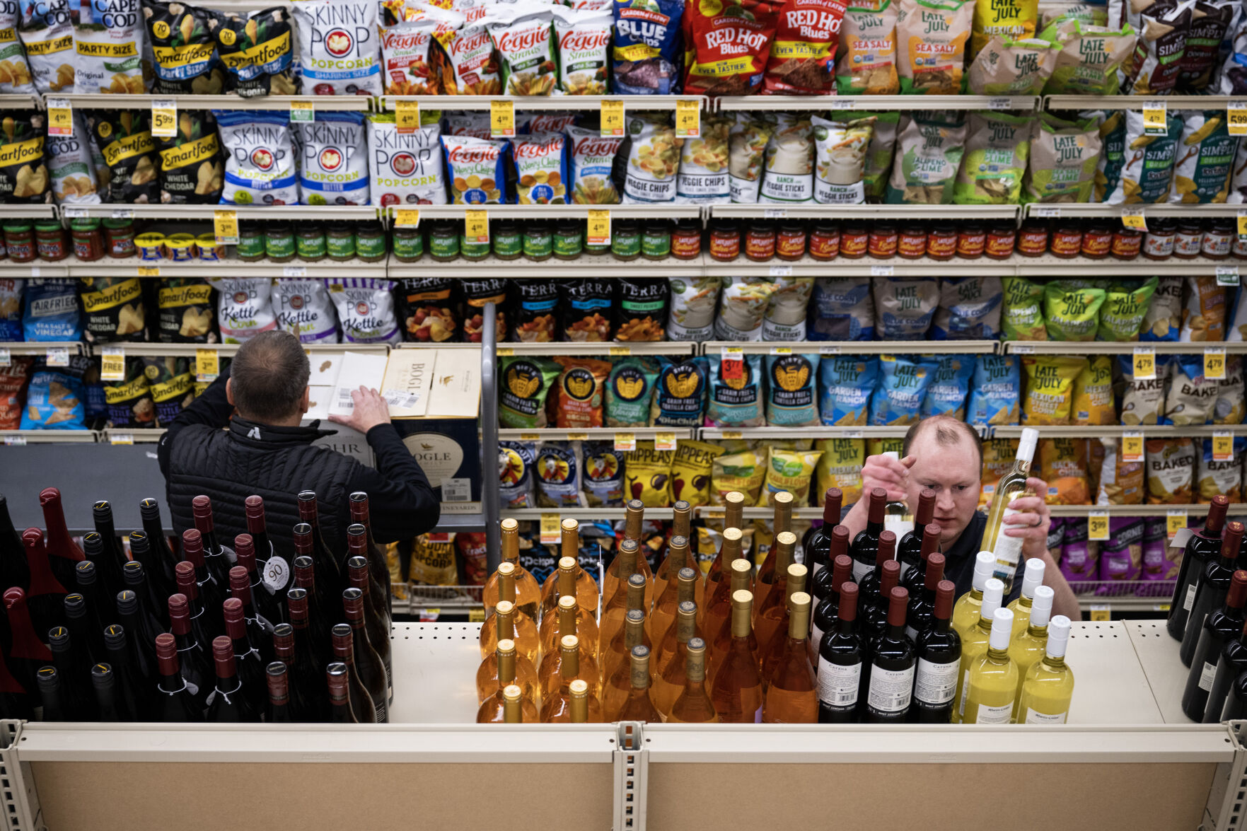 Bryan Morton, right, with E & J Gallo Winery and Jim Ruffcorn with the Brown–Forman Distilleries company help stock aisle three with wine on Wednesday morning, March 1, 2023, at the Safeway grocery store on South Havana Street in Aurora, Colo. (Timothy Hurst/Denver Gazette) (Timothy Hurst/Denver Gazette)