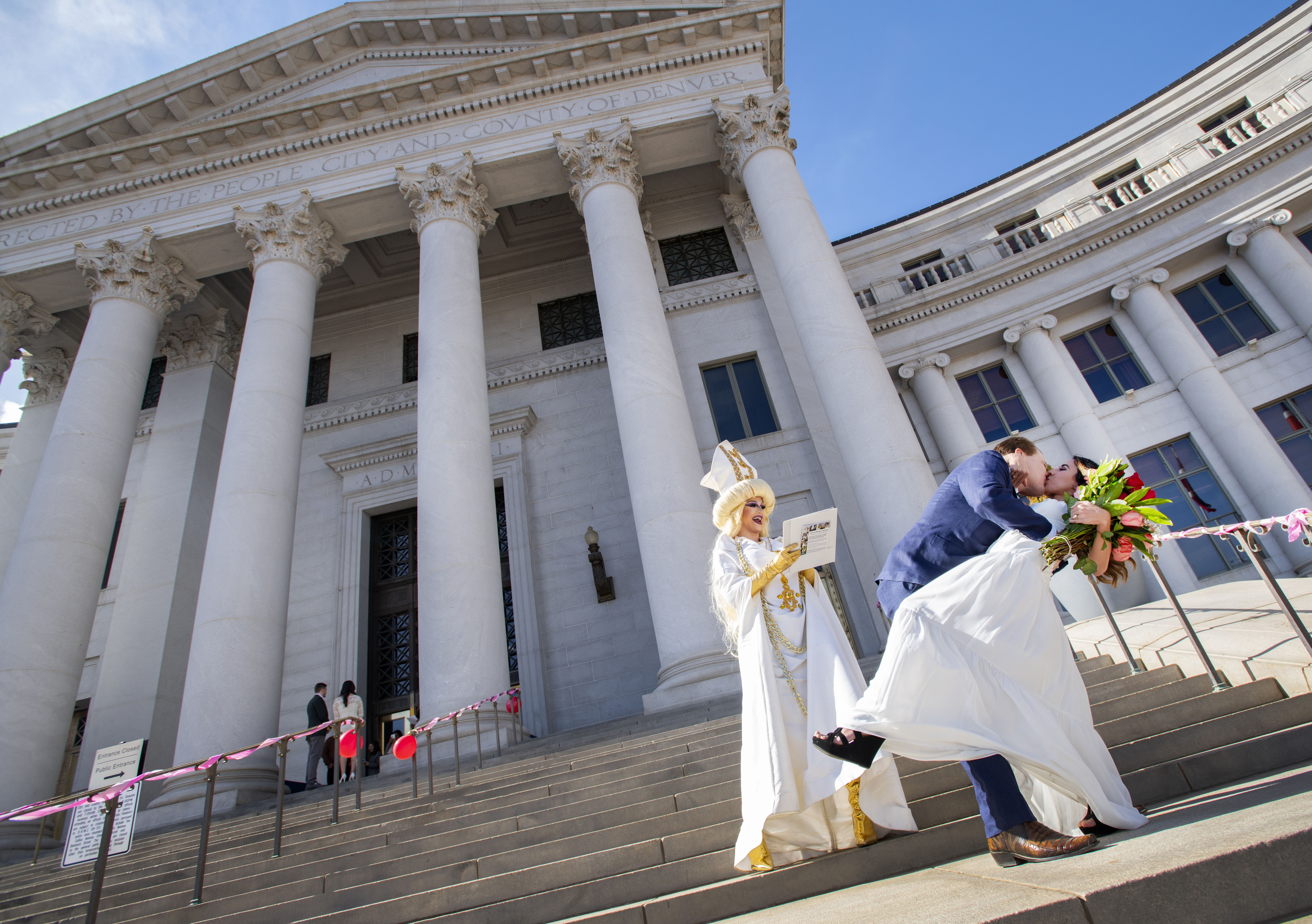 Dr. Zain Allison kisses his bride Tania Pena-Lfaro on the front steps of the Denver City and County building Tuesday, Feb. 14, 2023, as local drag performer Jessica L’Whor officiated during the Denver Marriage Marathon on Valentine's Day. Ten couples were married during the event. This year was the first year since 2019 it was held because of the pandemic. The couple met five years ago at the hospital where they both worked. Peno-Lfaro said it was 