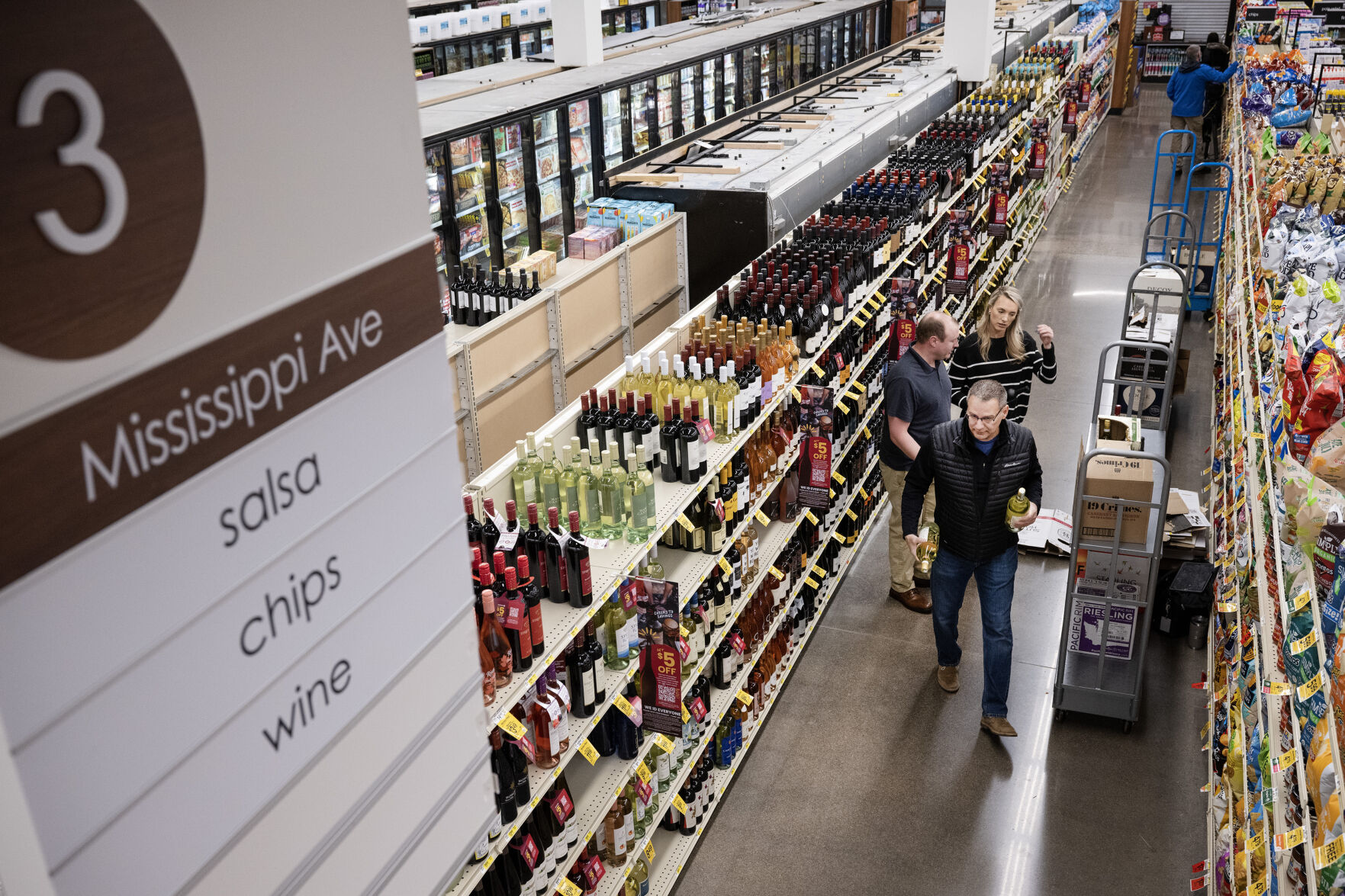 Jim Ruffcorn, front, with the Brown–Forman Distilleries company helps stock aisle three with wine on Wednesday morning, March 1, 2023, at the Safeway grocery store on South Havana Street in Aurora, Colo. (Timothy Hurst/Denver Gazette) (Timothy Hurst/Denver Gazette)