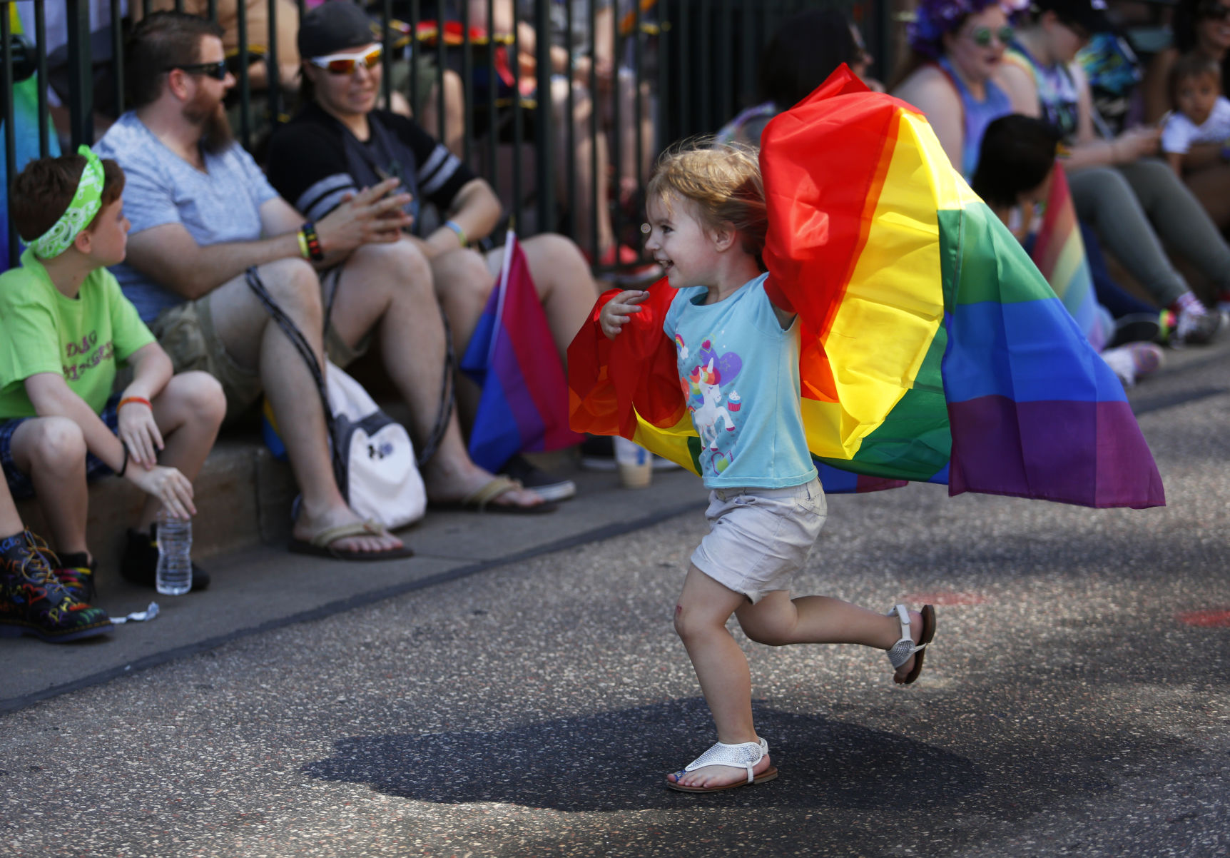 Lexie Bartnik, 3, runs with a rainbow flag during the Colorado Springs PrideFest Parade Sunday, July 9, 2017, on Tejon Street downtown. Photo by James Wooldridge, The Gazette (JAMES WOOLDRIDGE)