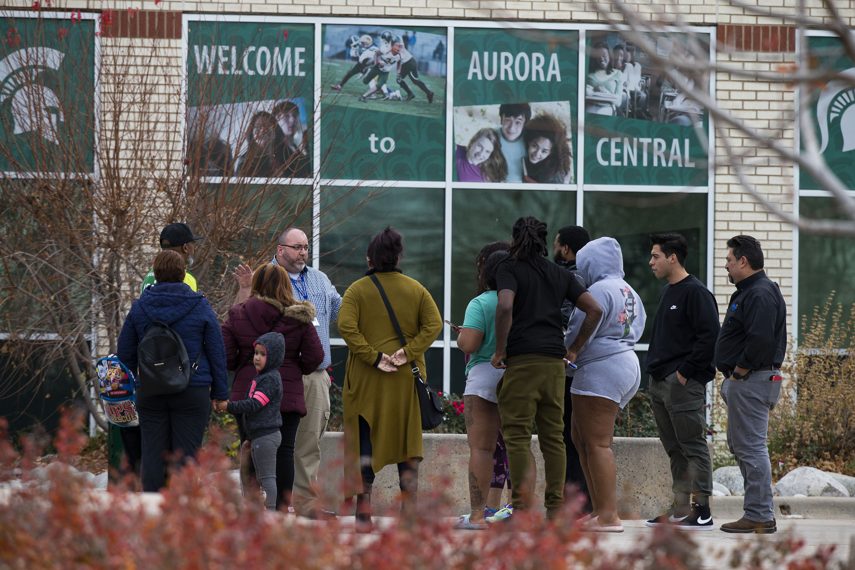 A school official talks with gathered community members outside Aurora Central High School which had restricted access due to a shooting that occurred at neighboring Nome Park on Monday, Nov. 15, 2021, in Aurora, Colo. (Timothy Hurst/The Gazette) (Timothy Hurst)