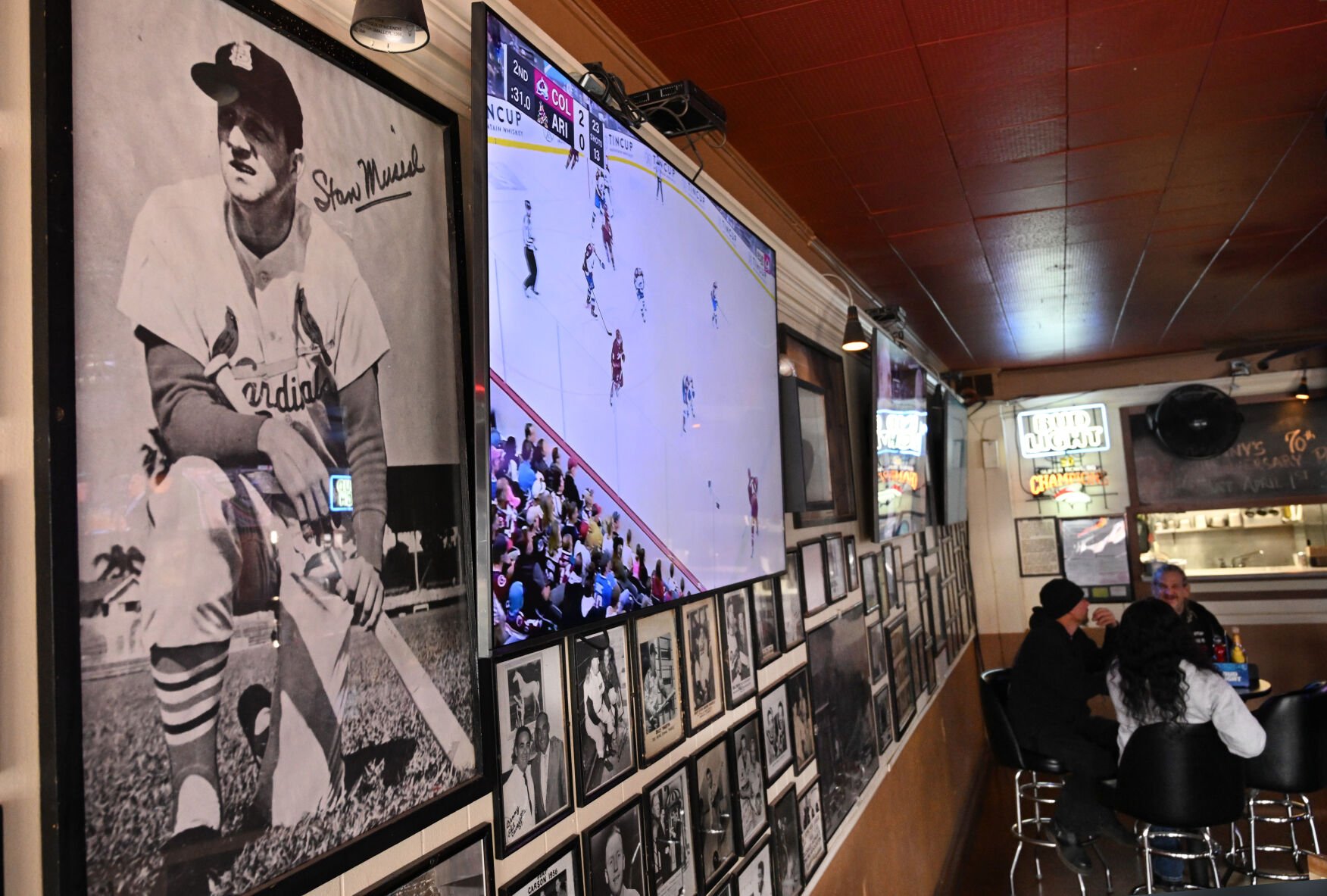 An autographed poster of legendary St. Louis Cardinal Stan “the Man” Musial has been hanging on the wall for years at Benny’s Restaurant & Lounge on Sunday, March 27, 2023, along with many other historical sports photos that have been lining the walls for decades. Seventy years ago, Benny’s Restaurant & Lounge was opened by Benny Raviotti, a local sports affiicianado and former minor league baseball player. An anniversary party will be held at the tavern on W. Colorado Ave. on Saturday. (Photo by Jerilee Bennett, The Gazette)