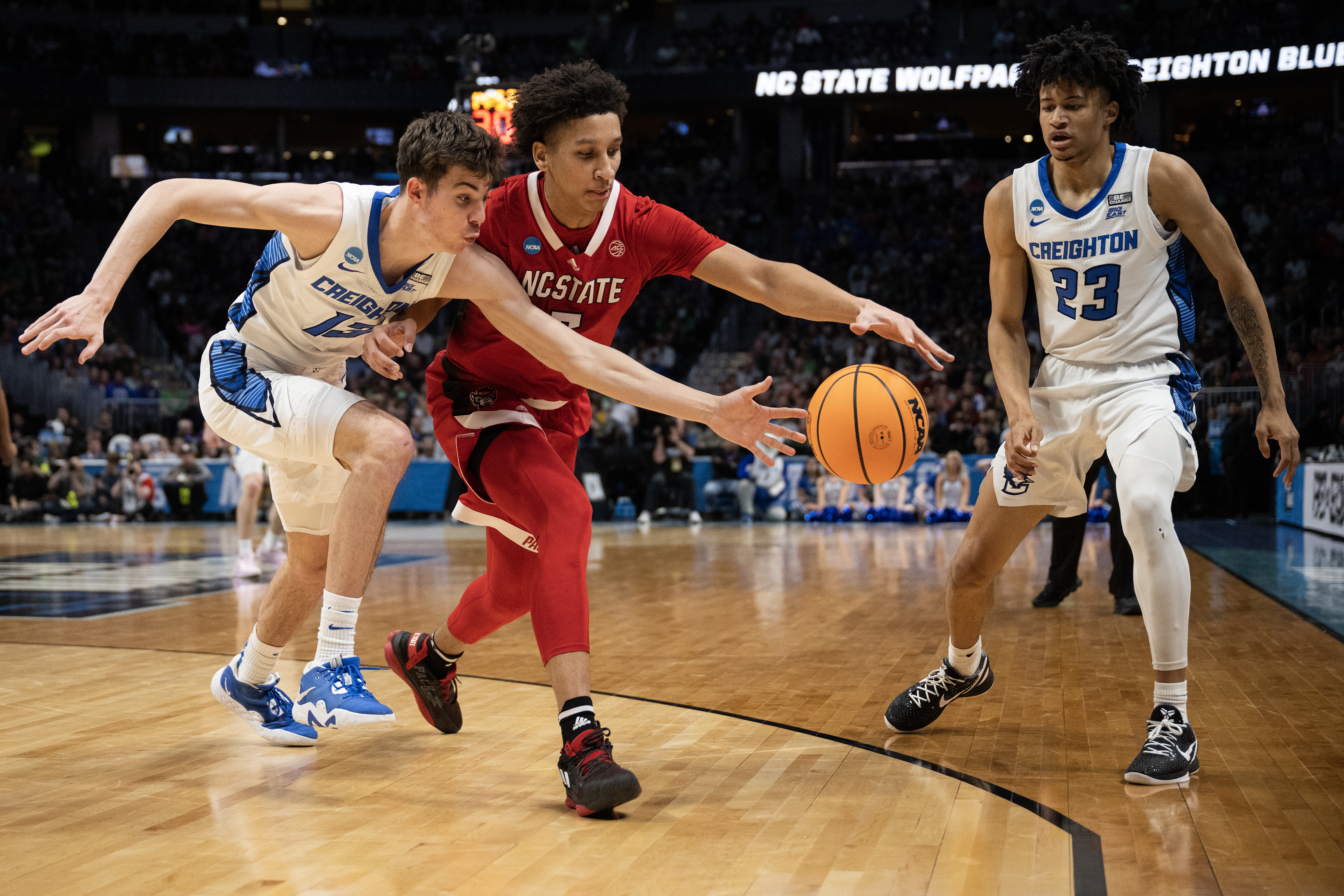 Creighton freshman forward Mason Miller (13) and North Carolina State guard Jack Clark (5) reach for a loose ball during a first-round college basketball game in the NCAA Tournament on Friday, March 17, 2023, at Ball Arena in Denver, Colo. (Timothy Hurst/Denver Gazette) (Timothy Hurst/Denver Gazette)