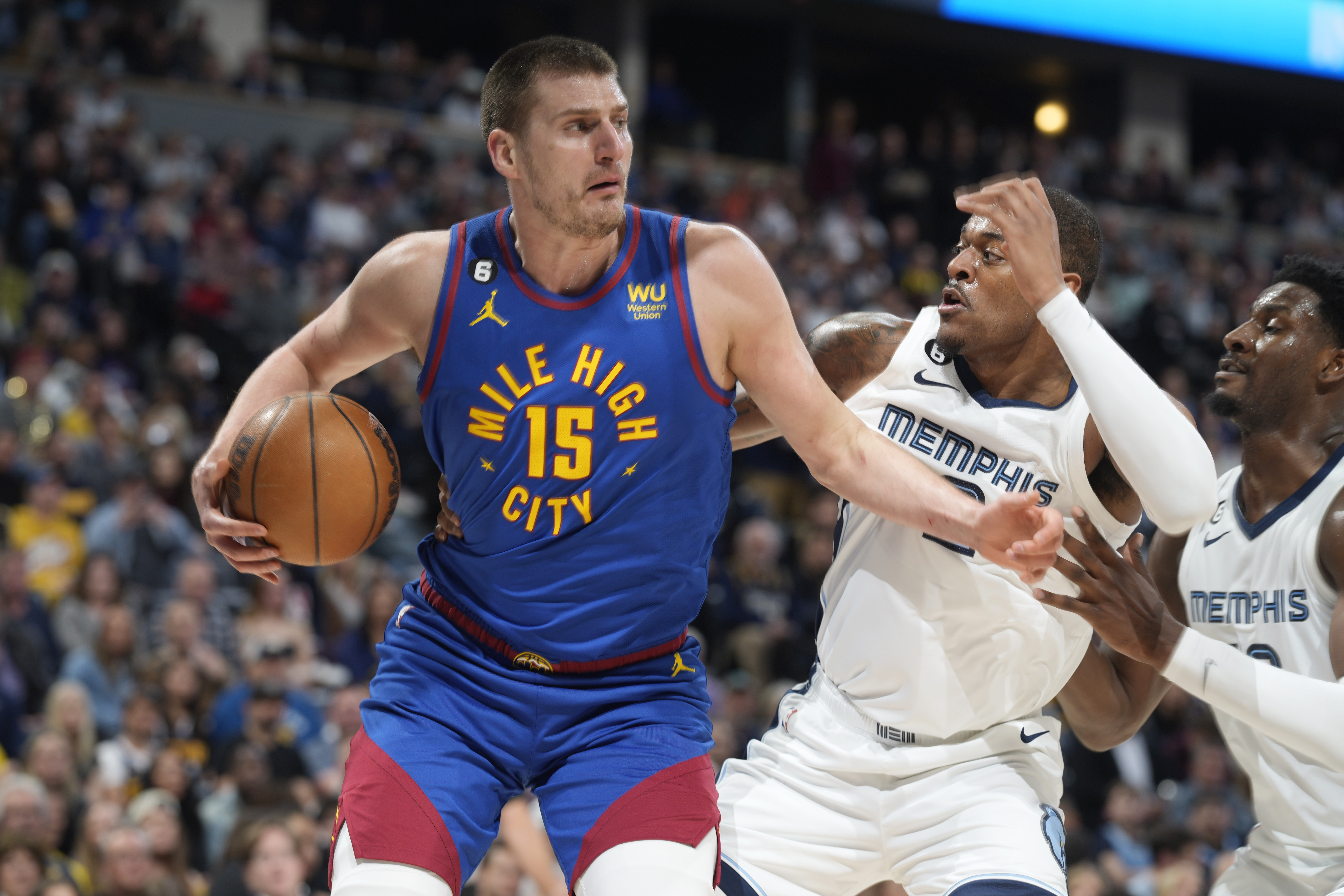 Denver Nuggets center Nikola Jokic, left, drives to the basket as Memphis Grizzlies forwards Xavier Tillman, center, and Jaren Jackson Jr. defend in the first half of an NBA basketball game Friday, March 3, 2023, in Denver. (AP Photo/David Zalubowski) (David Zalubowski)