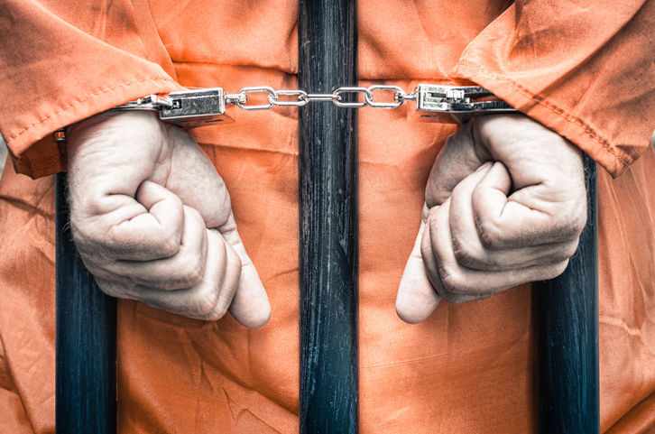 Handcuffed hands of a prisoner behind prison bars (copy) (copy) (Getty Images)