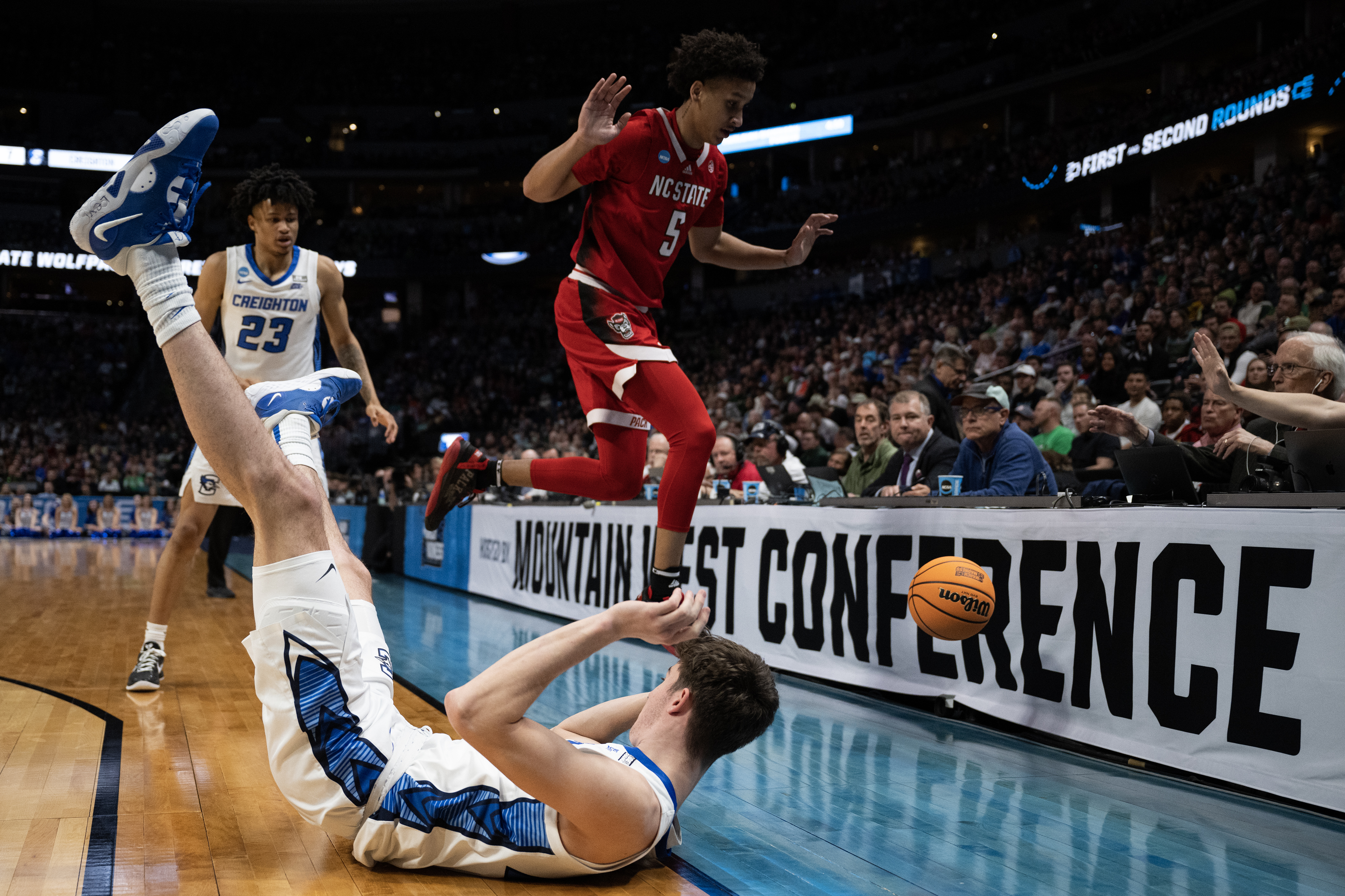 Creighton freshman forward Mason Miller (13) and North Carolina State guard Jack Clark (5) crash out of bounds after competing for a loose ball during a first-round college basketball game in the NCAA Tournament on Friday, March 17, 2023, at Ball Arena in Denver, Colo. (Timothy Hurst/Denver Gazette) (Timothy Hurst/Denver Gazette)