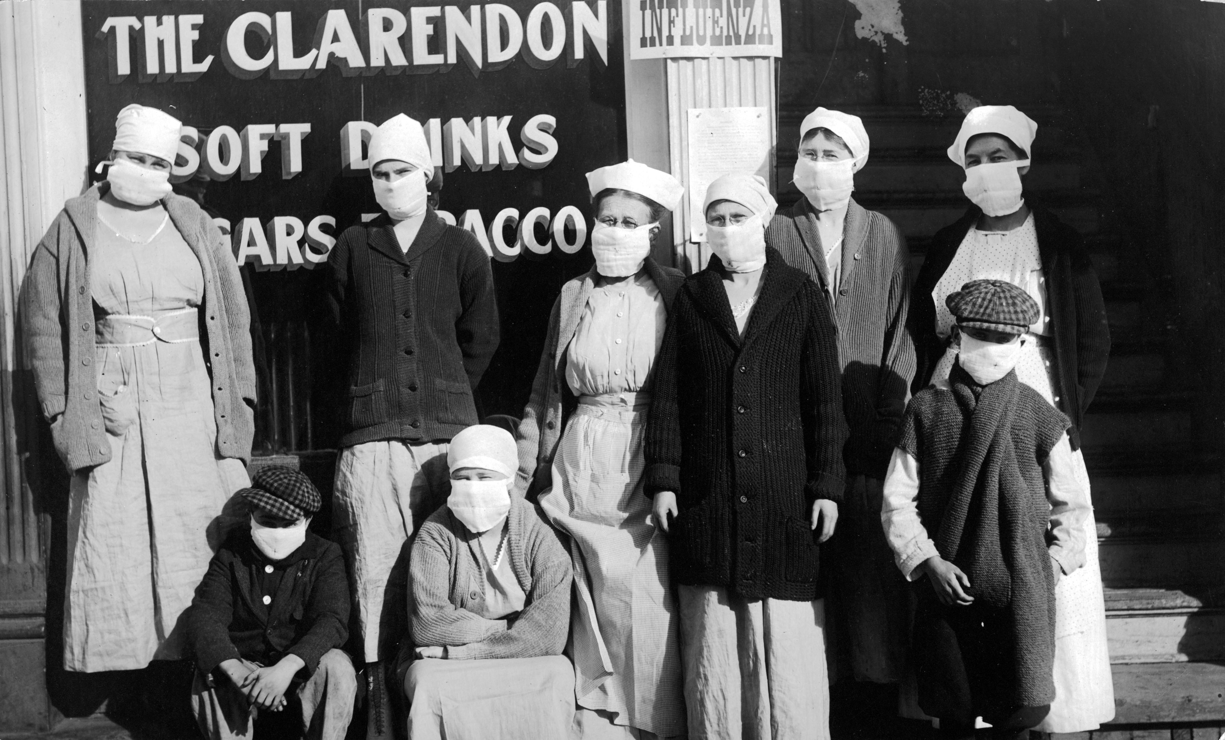 Nurses and children wearing masks stand outside a place called, 