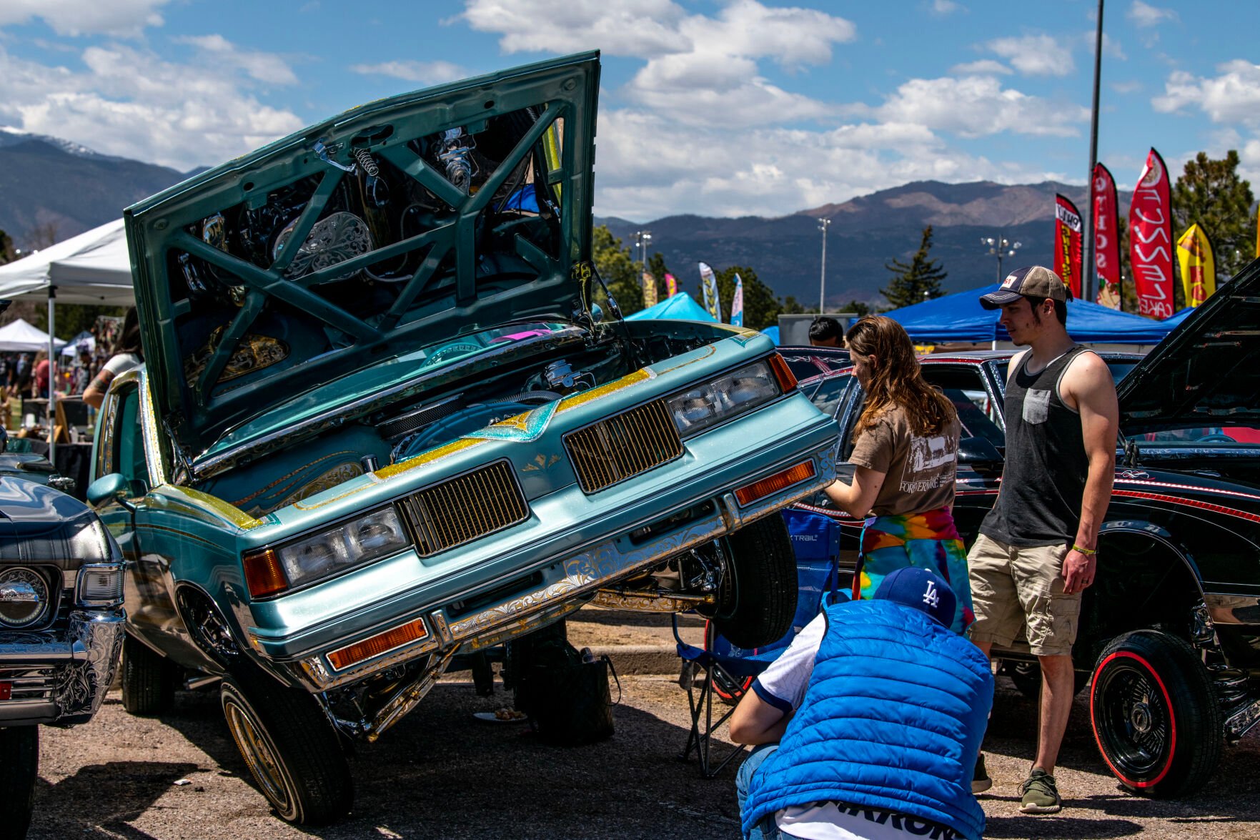 People stop to look at a lowrider at the 39th annual Cinco De Mayo Festival and Car Show at Memorial Park on Saturday. Over 100 cars bikes and motorcycles entered the car show Saturday, accompanied by more than 60 vendors and food trucks from the area. (Parker Seibold, The Gazette)