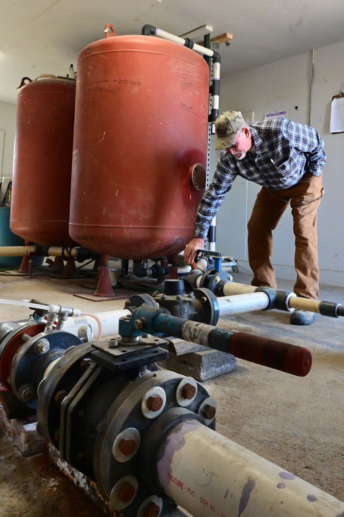 Norman Noe checks on the valves in front of giant iron filters that take iron out of the water for the South Swink Water Co.