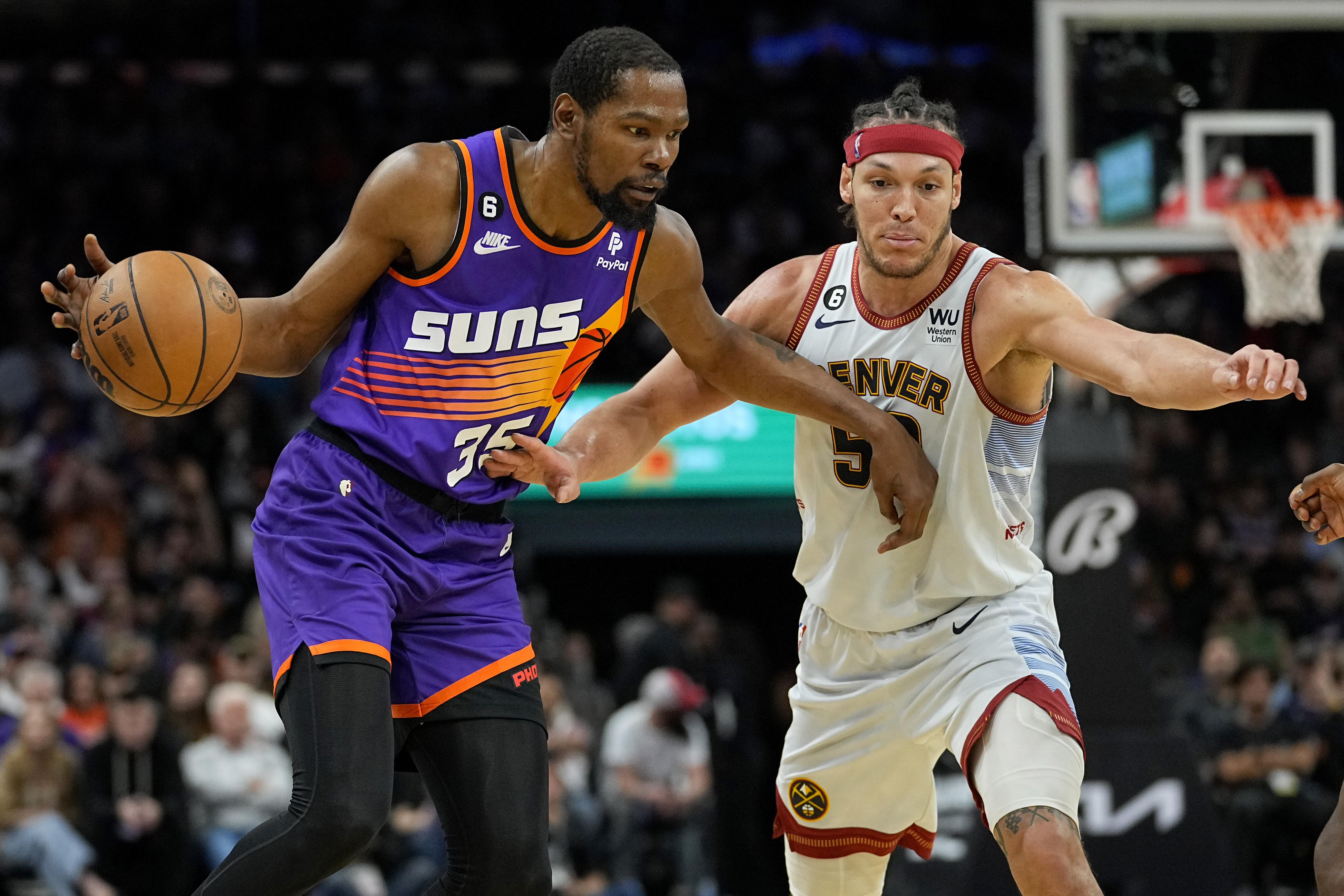 Phoenix Suns forward Kevin Durant (35) drives as Denver Nuggets forward Aaron Gordon (50) defends during the second half of an NBA basketball game, Friday, March 31, 2023, in Phoenix. (AP Photo/Matt York) (Matt York)