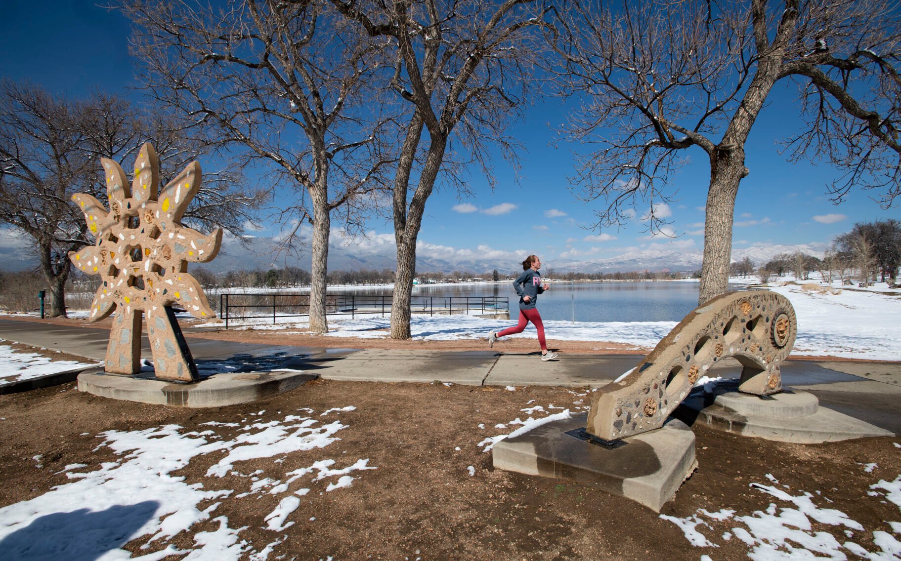 The snow melts quickly from the Helios, left, and Bridge sculptures in Memorial Park this month as a runner circles Prospect Lake. While much of Colorado saw above-average snowfalls this winter, Colorado Springs’ water collection sources got average levels of snowfall. (Christian Murdock, The Gazette)