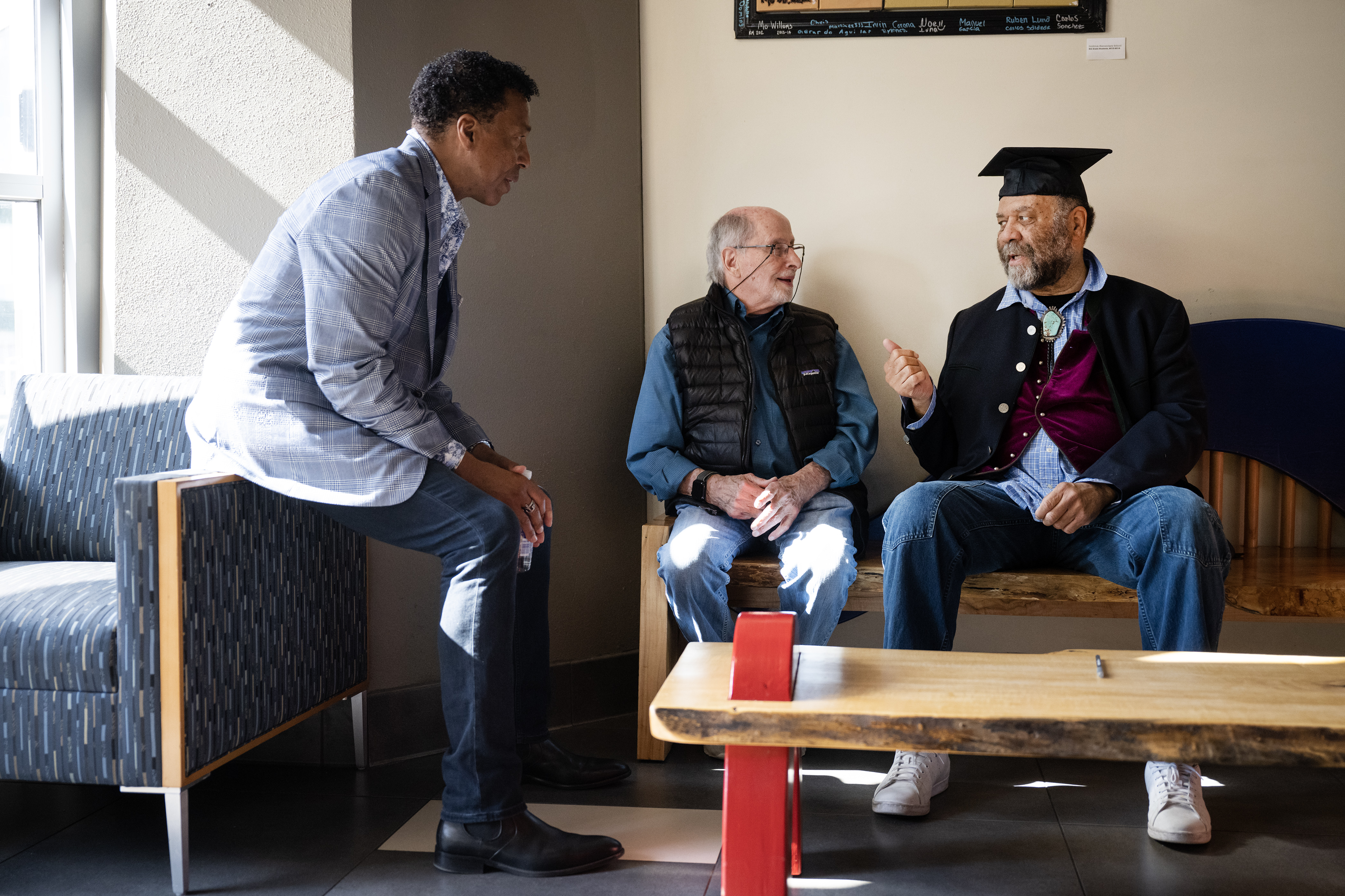 Denver Blues legend Otis Taylor, right, visits with lifeling friend Harry Tuft, center, and James Holmes, who Taylor mentored since Holmes’ childhood, before a graduation ceremony where the Denver Public Schools board would confer degrees to students who’s education was disrupted by the closing of Manual High School in 2006, as well as confer a degree to Taylor who was expelled 57 years ago for refusing to trim his hair, as seen on Monday, May 15, 2023, during a Denver Public Schools Board of Education meeting in Denver. (Timothy Hurst/Denver Gazette) (TimHursttim.hurst@gazette.comhttps://secure.gravatar.com/avatar/aca82bd62b4ee425c598527cd6faa1b1?d=mm&r=g)