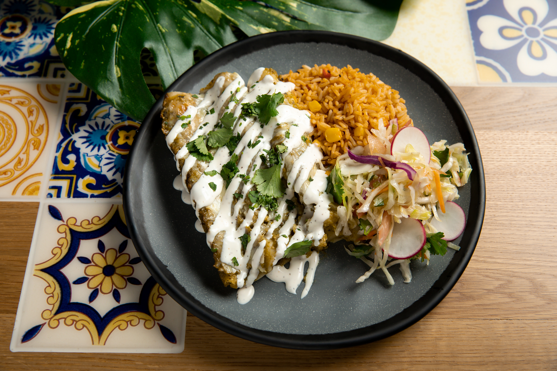 A plate featuring Casa Bonita’s Green Chile Enchilada entree shown here in a photo released May 26, 2023 by the restaurant. (Jennifer Olson/Casa Bonita)