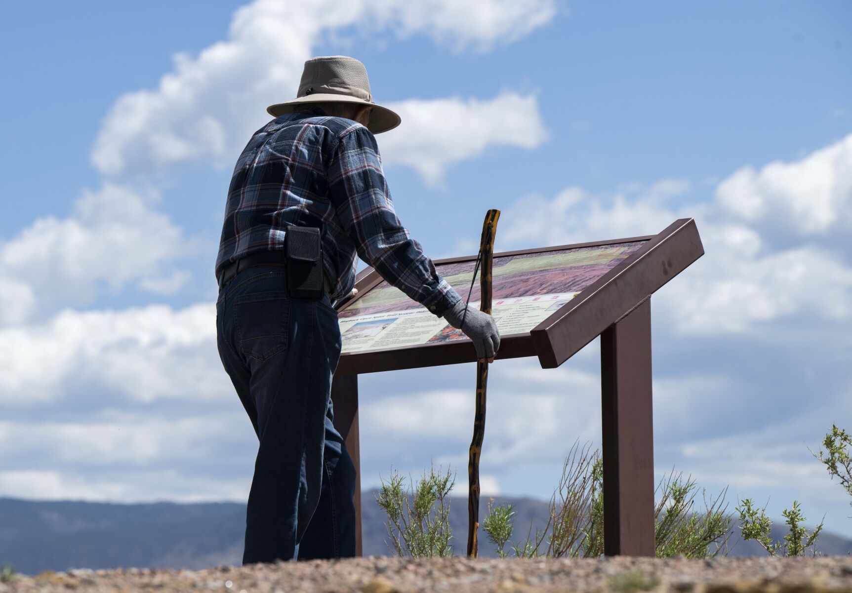 Don Wallace of Cañon City looks at the trail map after climbing to Skyline Drive from his home below Tuesday, May 16, 2023. Wallace has lived in the area for five years and hikes the trails in the Hogback Open Space Recreation Area three to four times a week. (The Gazette, Christian Murdock) (Christian Murdock/The Gazette)
