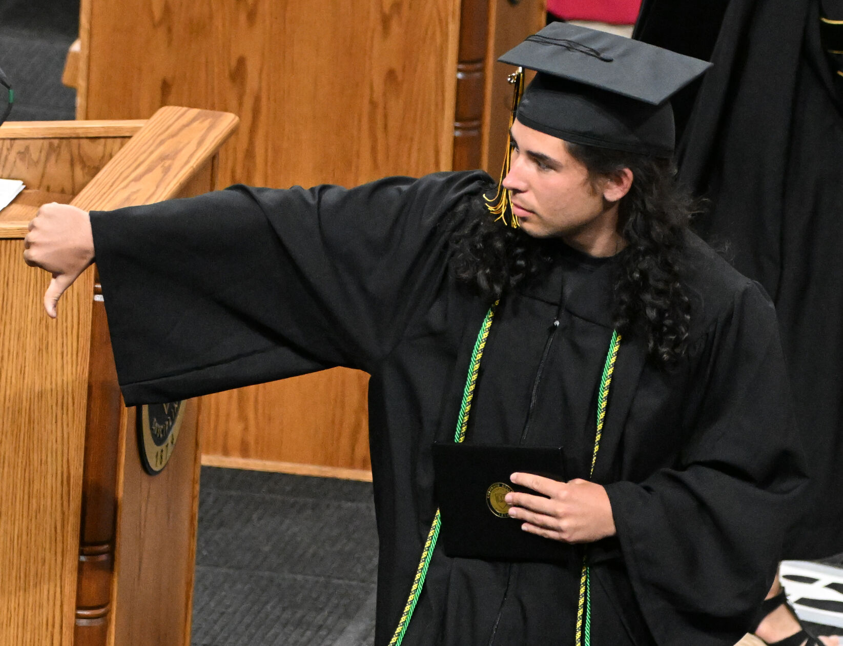 One Colorado College graduating student gives the thumbs down to Liz Cheney as he walks across the stage to receive his diploma. (Photo by Jerilee Bennett, The Gazette)