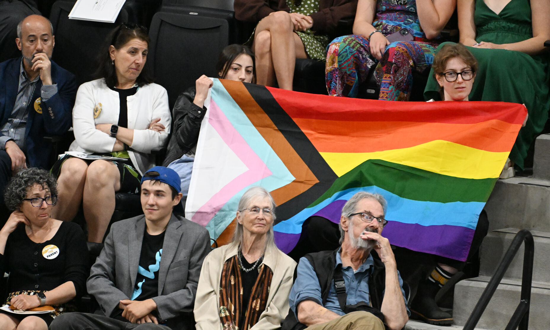Members of the audience hold up a Progress Pride Flag during the speech of former former U.S. Rep. Liz Cheney, R-Wyo. In 2013, Cheney was opposed to same sex marriage, but in 2021, admitted in a 60-Minutes interview that she was wrong. (Photo by Jerilee Bennett, The Gazette)