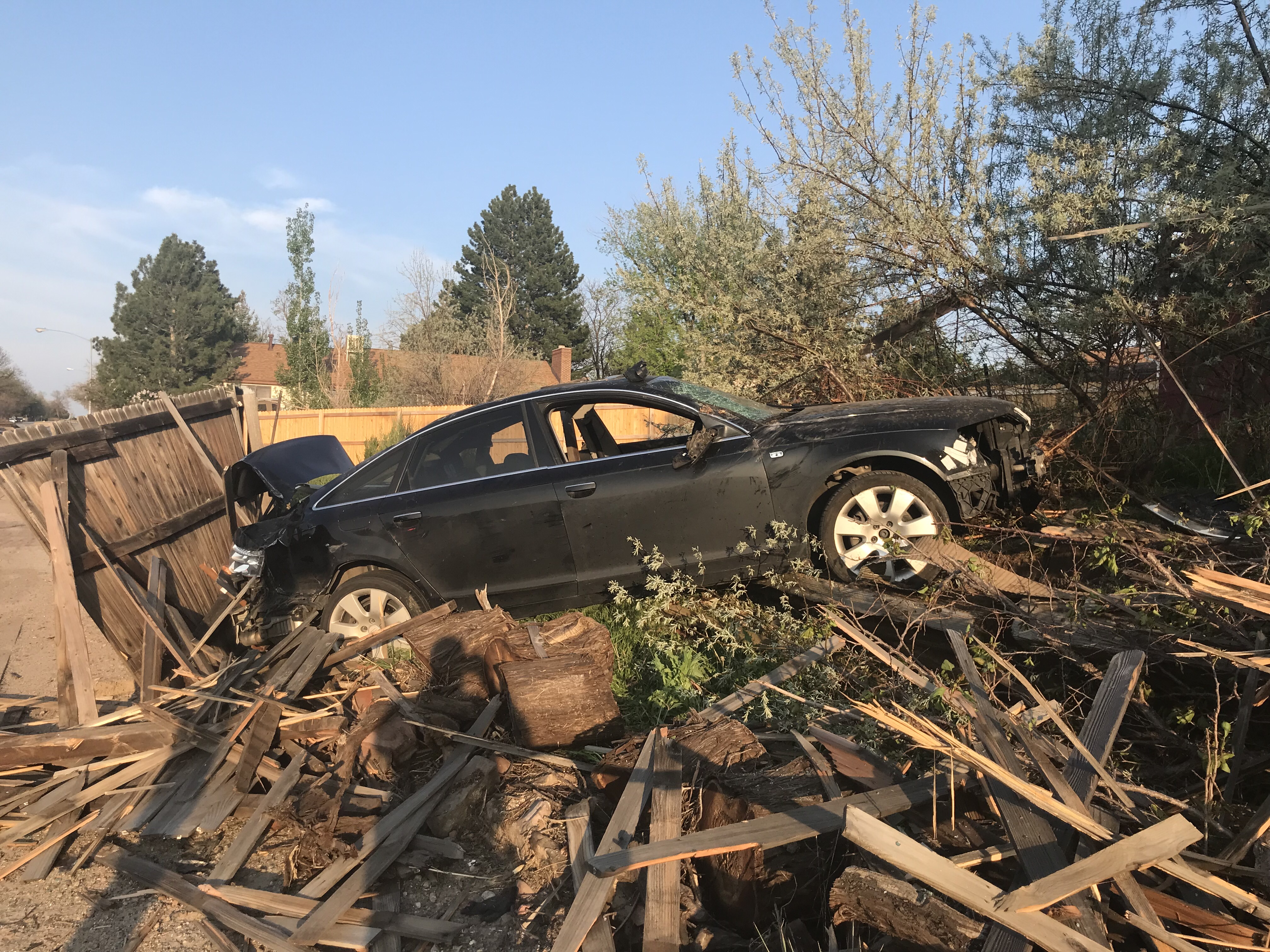A wrecked vehicle sits in a the back yard of a house after Arapahoe County Sheriff deputies performed at tactical vehicle intervention in Sunday, May 21, 2023 in Aurora, Colorado. The vehicles carried two men who are suspected of firing shots at Cherry Creek State Park. (Arapahoe County Sheriff's Office)