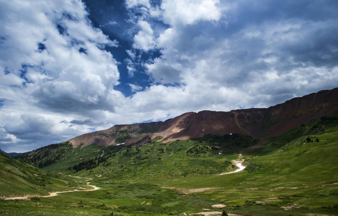 A vehicle drives through Paradise Basin Monday, July 18, 2016, toward Schofield Pass with Mt. Baldy in the background on a summer day near Crested Butte. The basin was filled with wildflowers as the Crested Butte Wildflower Festival continues through Ju...