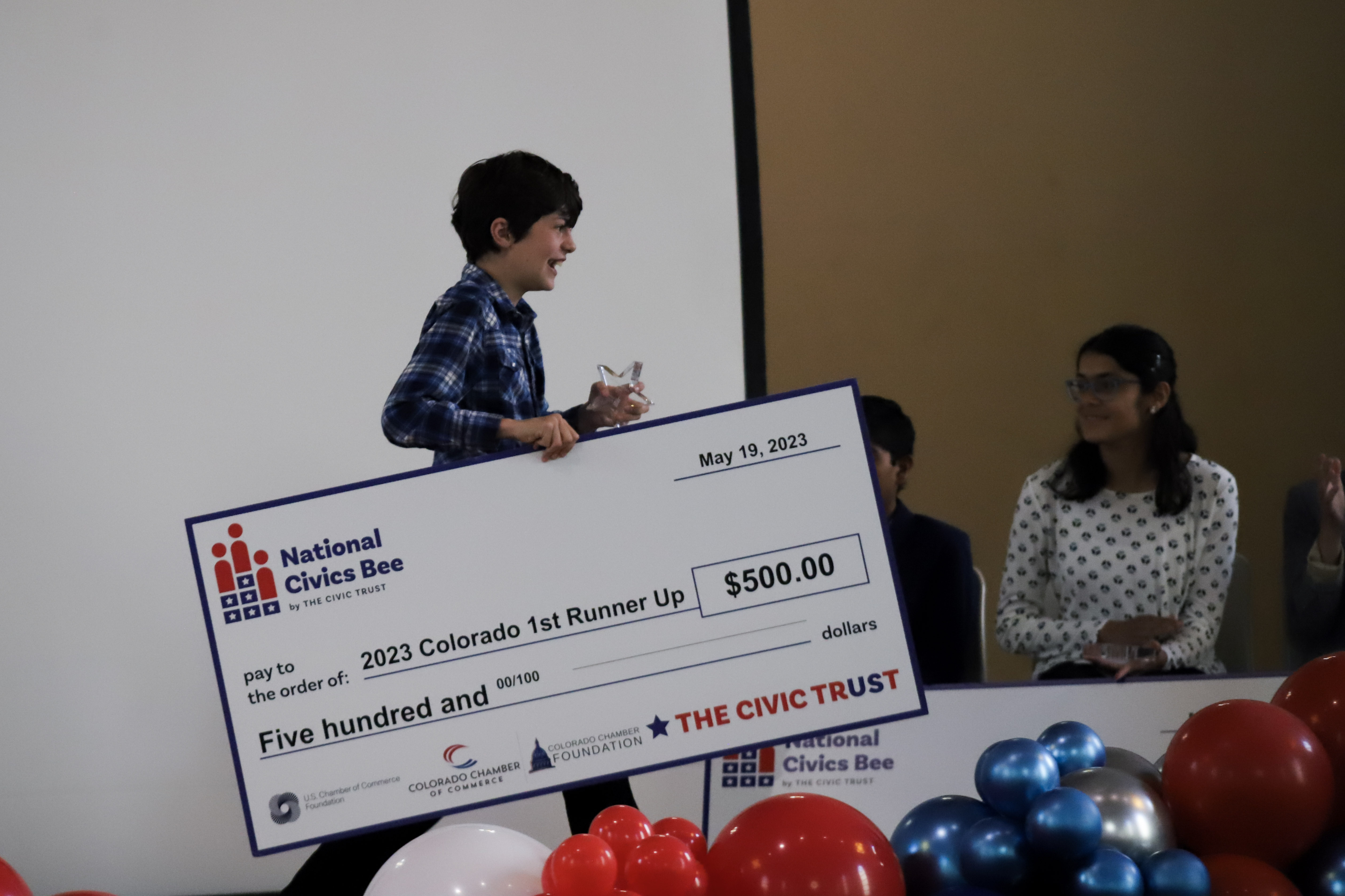 Joseph Drexler walks across the stage with his monetary prize after winning second place at the Colorado state Civics Bee competition Friday at St. Cajetan’s on the Auraria Campus in Denver. (KylaPearceAurora reporterkyla.pearce@denvergazette.comhttps://denvergazette.com/content/tncms/avatars/2/16/1e5/2161e54a-3f47-11ed-bc0c-ff41892600ae.4fb8f678b9b96eab286c33c5af828fe7.png)