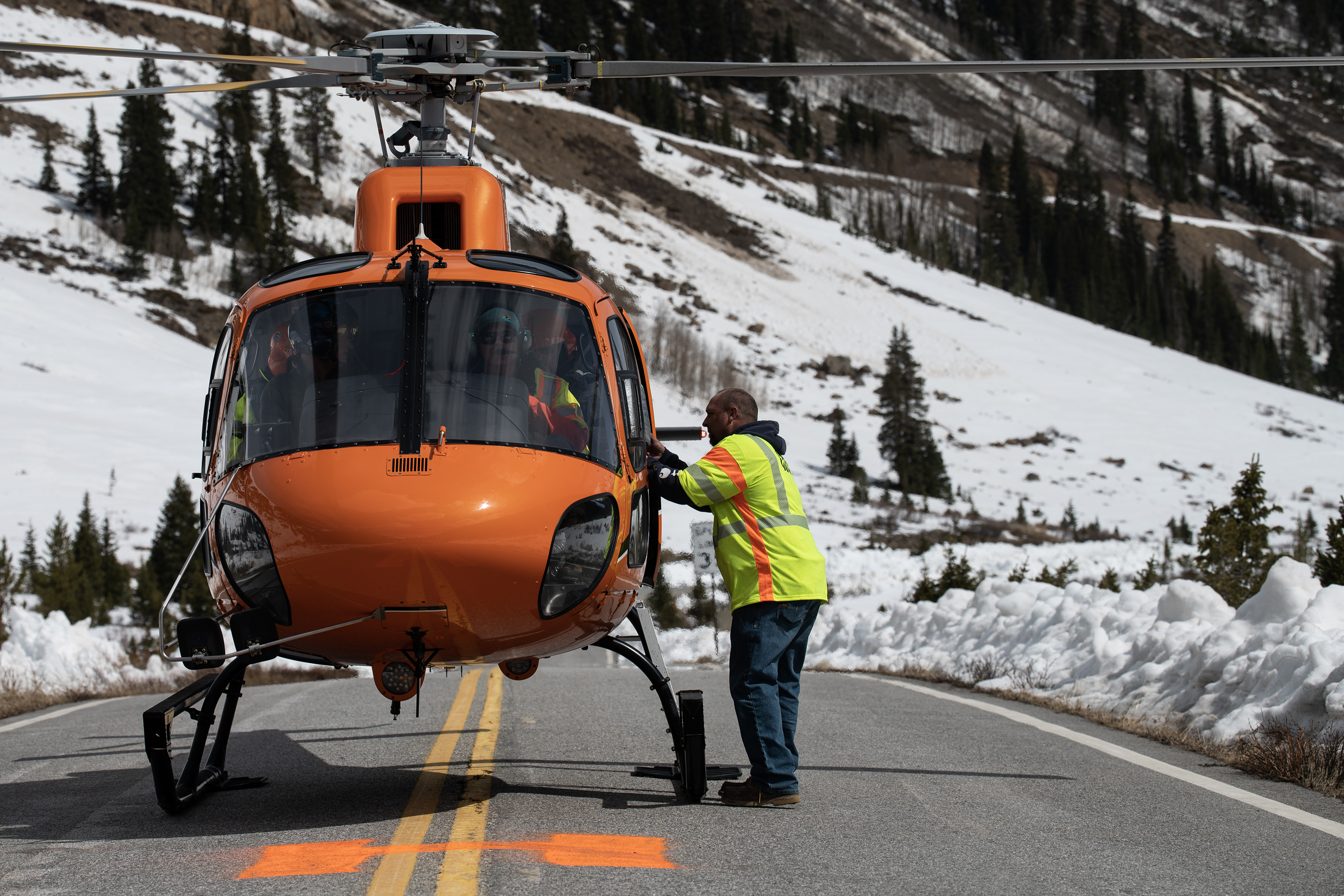 A Colorado Department of Transportation crew member hands the last of the “turkey bomb” explosives to a crew in the helicopter before it heads to the saddle of the mountain to blast the overhanging snow slab and trigger an avalanche during a mission to conduct avalanche mitigation off Colorado 82 on the east side of Independence Pass on Tuesday, May 2, 2023, in Lake County, Colo. (Timothy Hurst/Denver Gazette) (TimHursttim.hurst@gazette.comhttps://secure.gravatar.com/avatar/aca82bd62b4ee425c598527cd6faa1b1?d=mm&r=g)