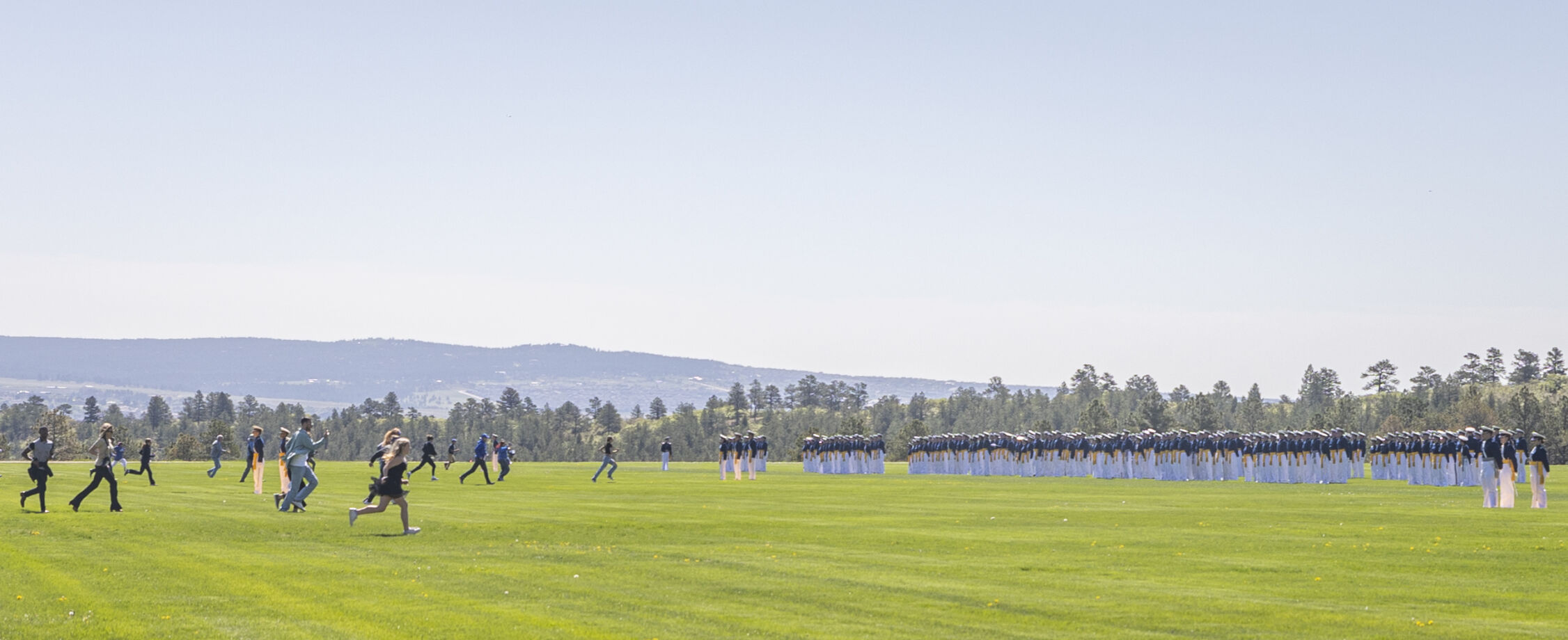 Graduating cadets’ friends and family rush Stillman Field to, ‘tap out,’ their graduate after the U.S. Air Force Academy Class of 2023 Graduation Parade in Colorado Springs, Co., on Wednesday, May 31, 2023. ‘Tapping out,’ is a tradition where the cadet’s family must tap them in order to put them at ease after the parade. (Gabi Broekema)