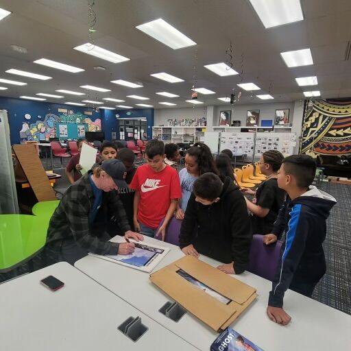 Chris Anthony signs autographs for fifth-graders at McGlone Academy in Denver's Montbello neighborhood before a field trip to Snobahn Indoor Ski and Snowboard in Centennial. (Courtesy, McGlone Academy)