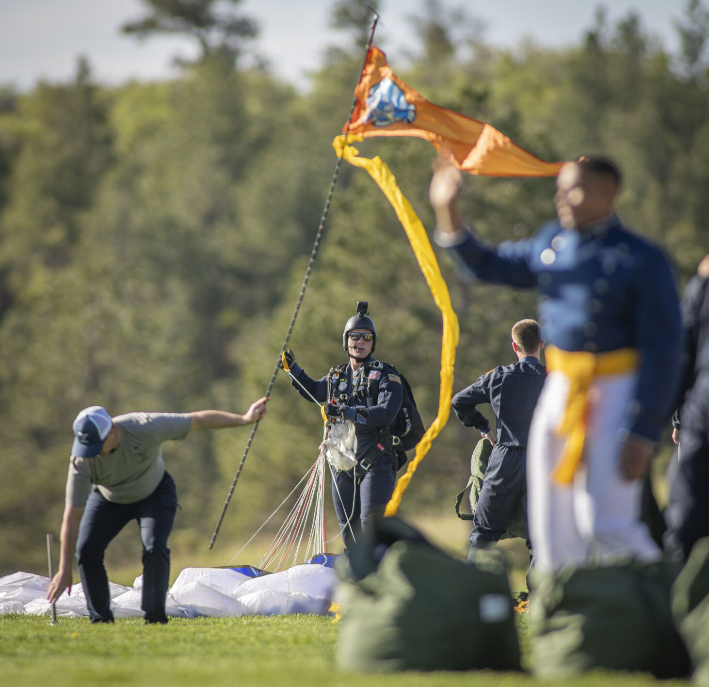 Cadet Dan Smith gathers his parachute after landing on Stillman Field at the U.S. Air Force Academy Class of 2023 Graduation Parade in Colorado Springs, Co., on Wednesday, May 31, 2023. (Gabi Broekema)