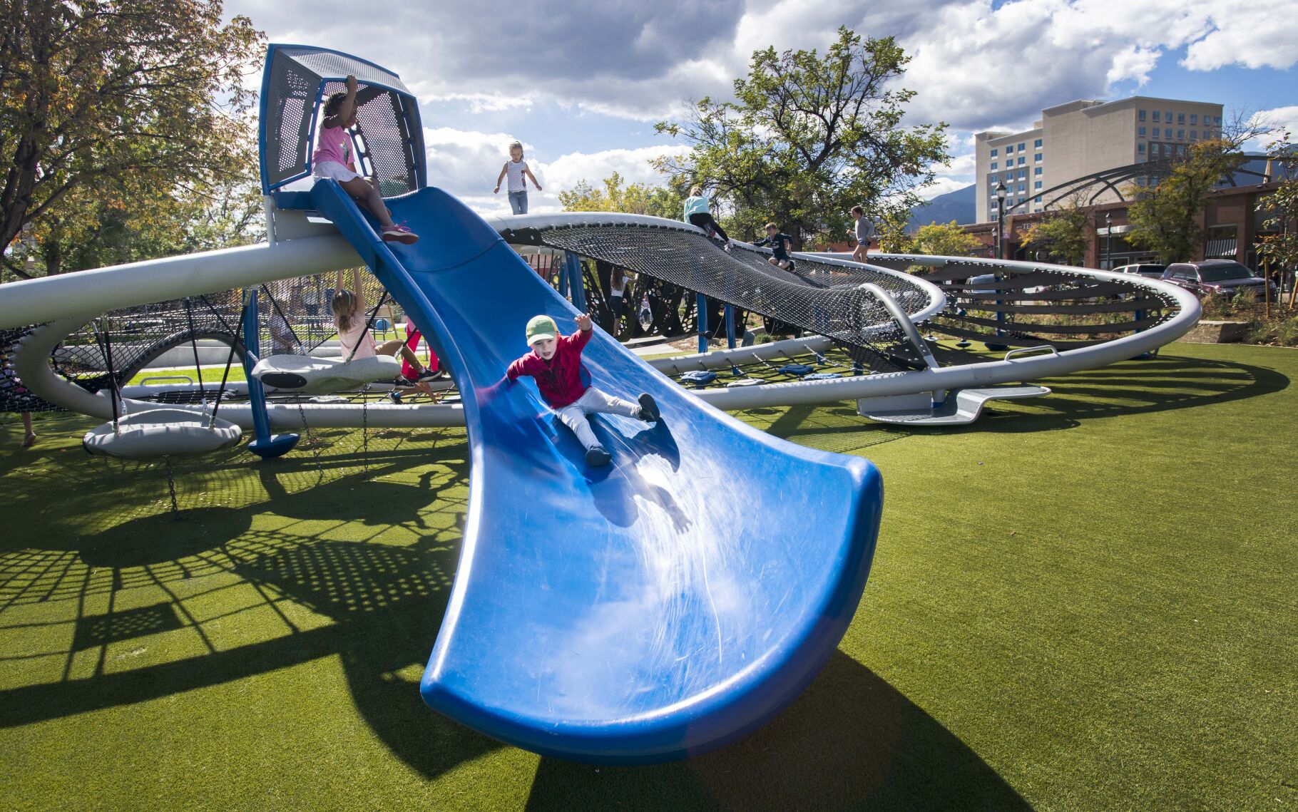 Theodore Van Valkenburg, 4, rides the slide on the playground equipment in downtown Colorado Springs’ Acacia Park in October. (Christian Murdock, The Gazette)