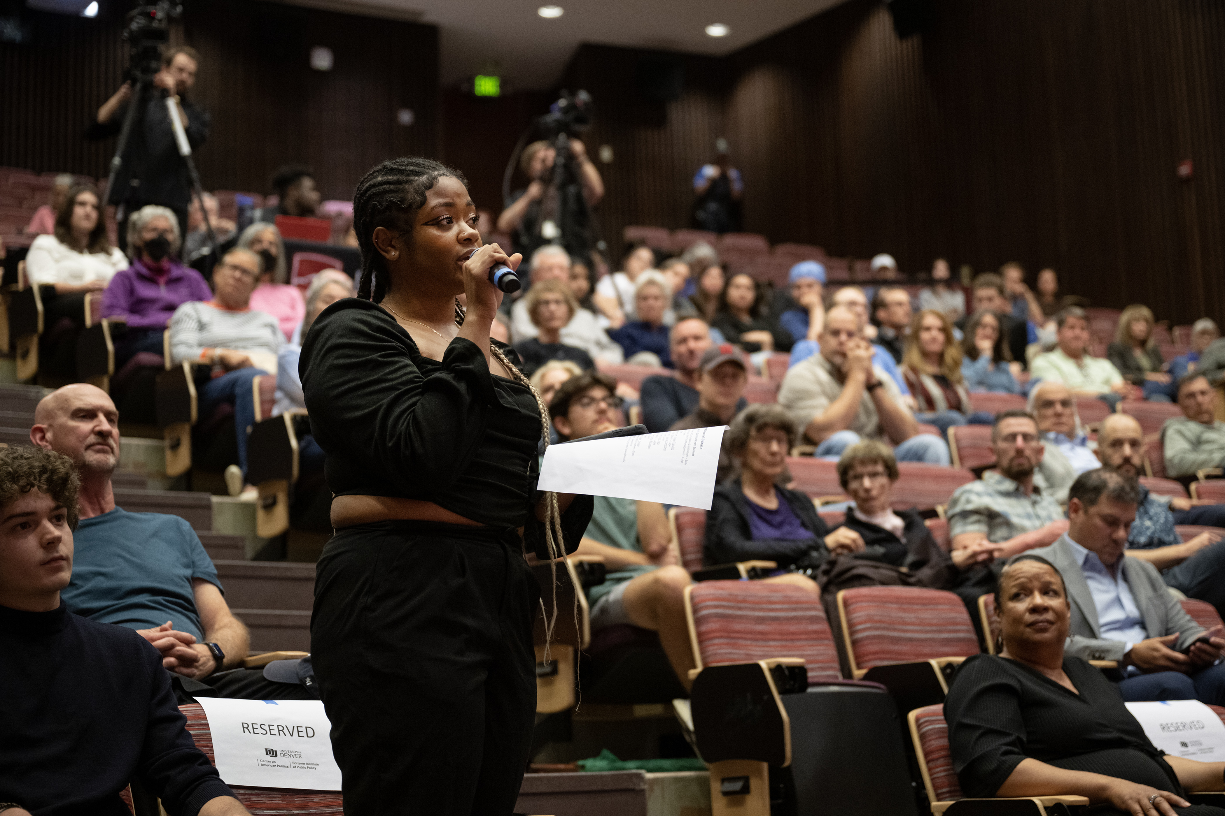 University of Denver undergraduate student Kania Campbell asks Denver mayoral run-off candidates Kelly Brough and Mike Johnston, not pictured, a question about gang violence during a debate on Thursday, May 18, 2023, in the Sam & Freda Davis Auditorium at the University of Denver in Denver, Colo. (Timothy Hurst/Denver Gazette) (TimHursttim.hurst@gazette.comhttps://secure.gravatar.com/avatar/aca82bd62b4ee425c598527cd6faa1b1?d=mm&r=g)