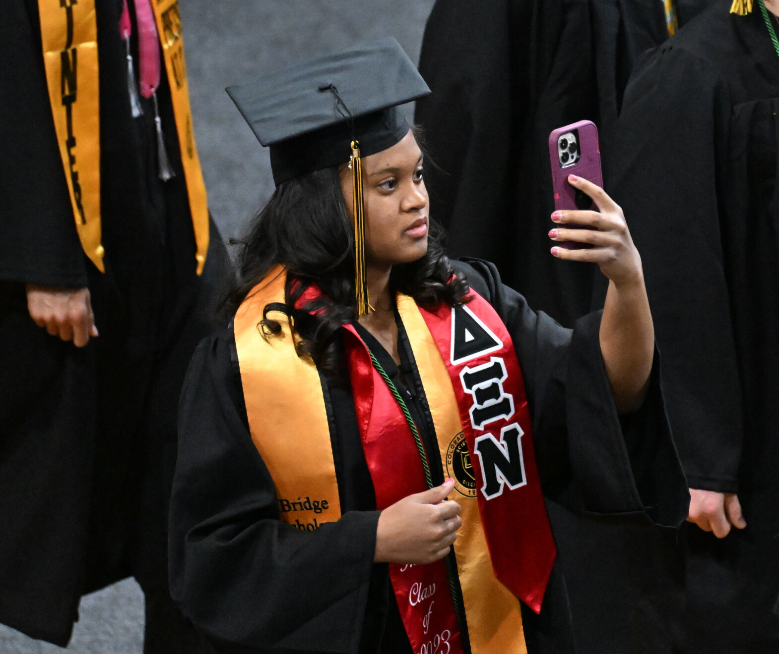 A student documents her graduation ceremony as she enters Ed Robson Arena for they graduation ceremony. (Photo by Jerilee Bennett, The Gazette)