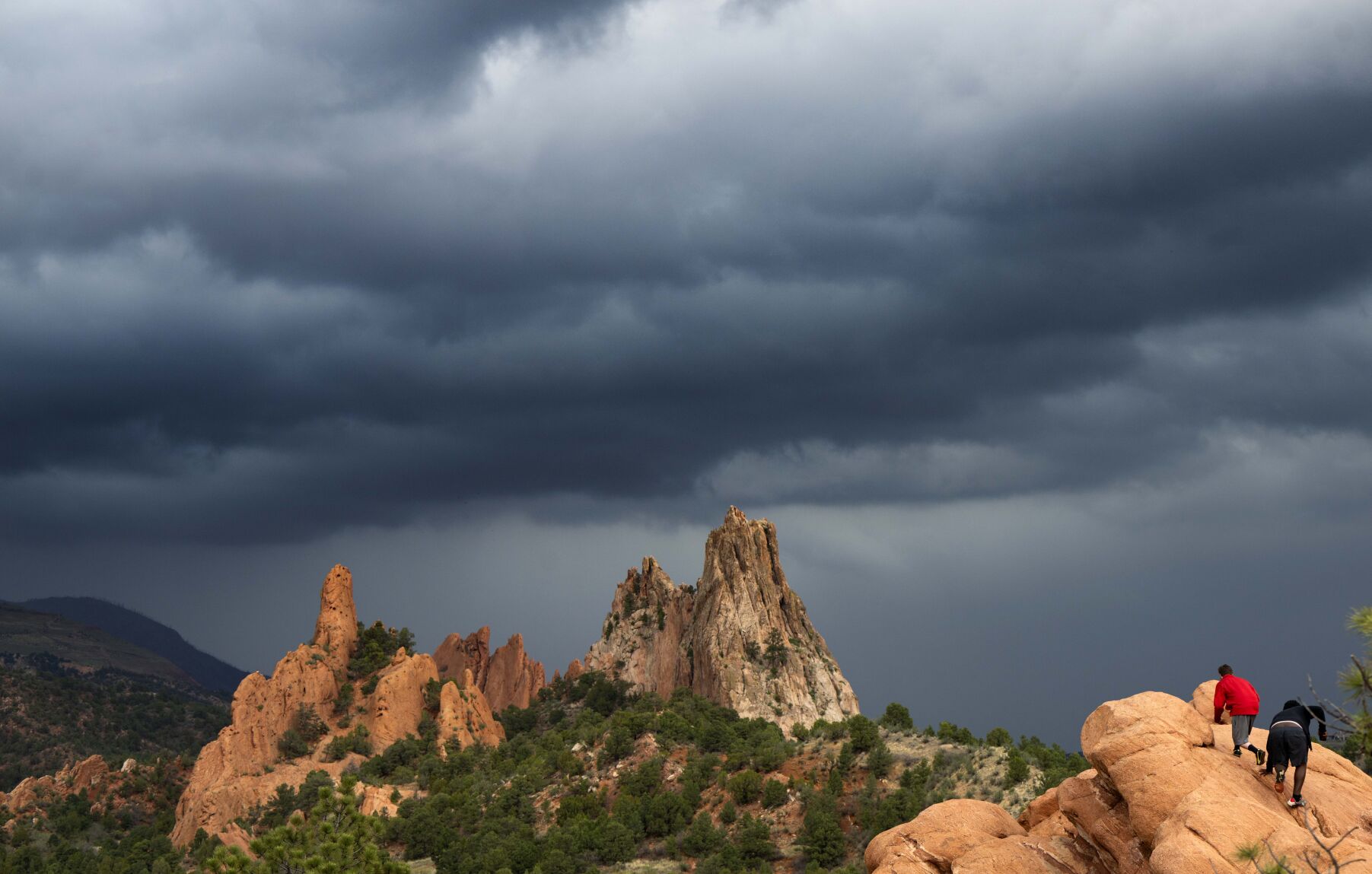 Ari Scheer, left, and Marcus Epps explore a rock formation in Garden of the Gods Park in Colorado Springs, Colo., Thursday, May 18, 2023, as a storm begins to hit the Pikes Peak Region. Scheer and Epps moved to Colorado Springs about three week ago from Atlanta, Ga. (The Gazette, Christian Murdock) (Christian Murdock/The Gazette)