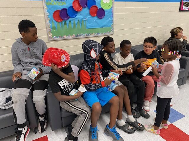A group of 9-12 year-olds who attended the Aztlan Recreation Center's summer kick-off event June 3 pile up together on a couch in the lobby. They plan on spending lots of time at the rec center pool this summer. (Carol McKinley)