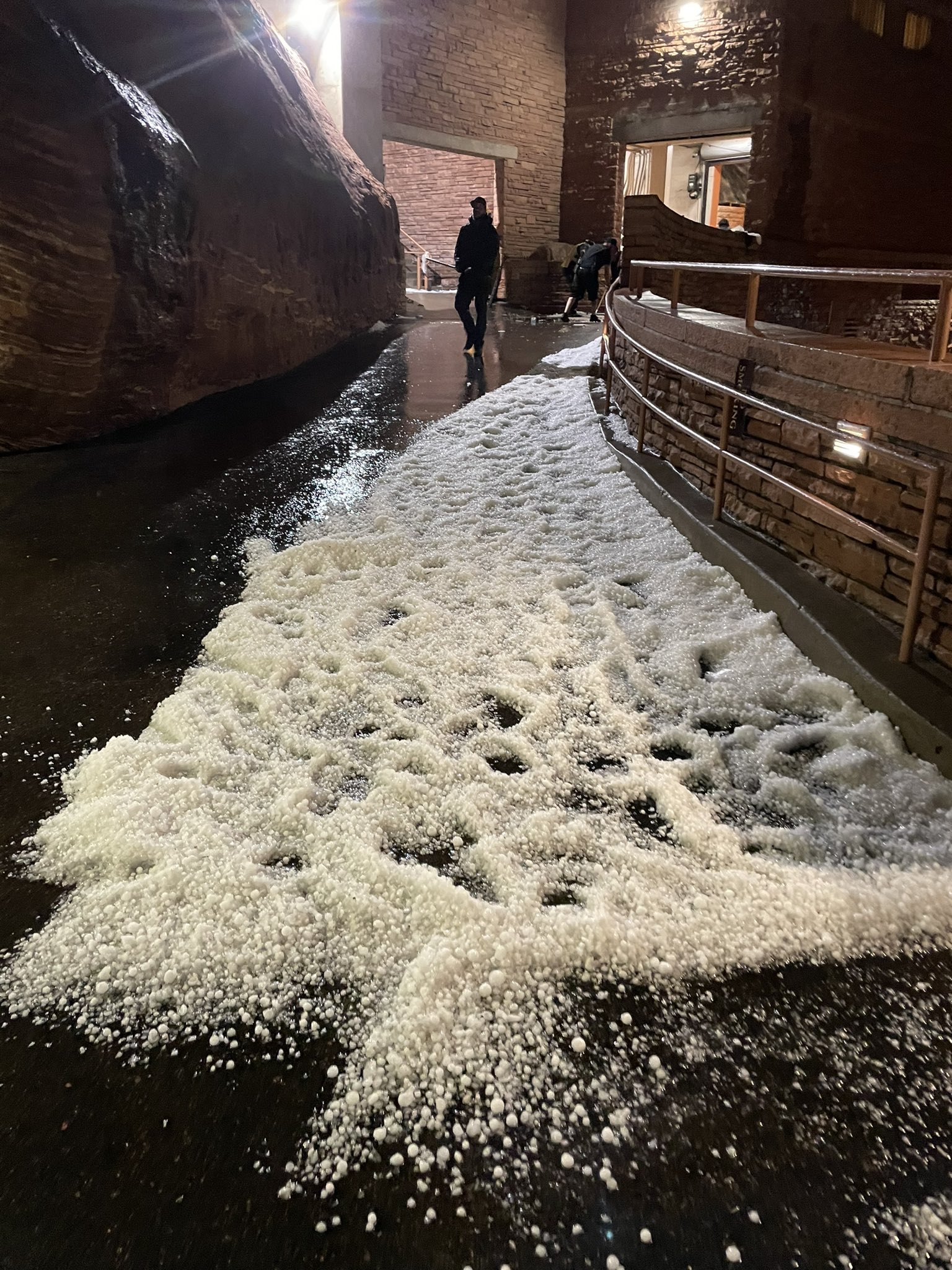 Hails stones lay on a walkway at Red Rocks Amphitheater on Wednesday, June 21, 2023 in Morrison, Colorado. Seven people were hospitalized and 80-plus injured as a large hailstorm pounded the concert venue during the Louis Tomlinson concert. (West Metro Fire)