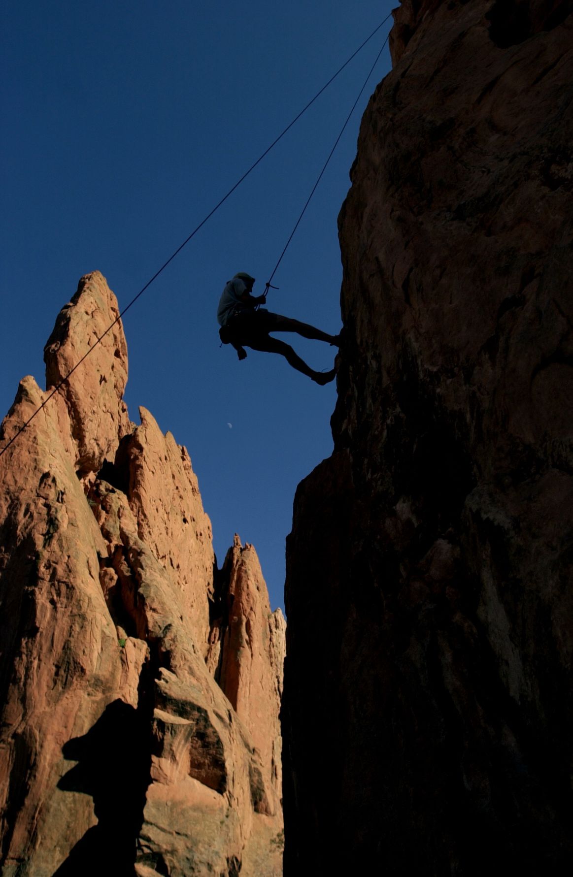 Don Lucas from Austin, Texas repels down a rock in Garden of the Gods with help from his friend Sean Gehlen from Washington State, who was below on the belay rope. The pair were taking a break from Philmont Ranch near Taos, New Mexico where they are backpacking guides that teach Boy Scouts the basics of backpacking and backcountry survival at the ranch. This was their first time climbing on sandstone. (Carol Lawrence)