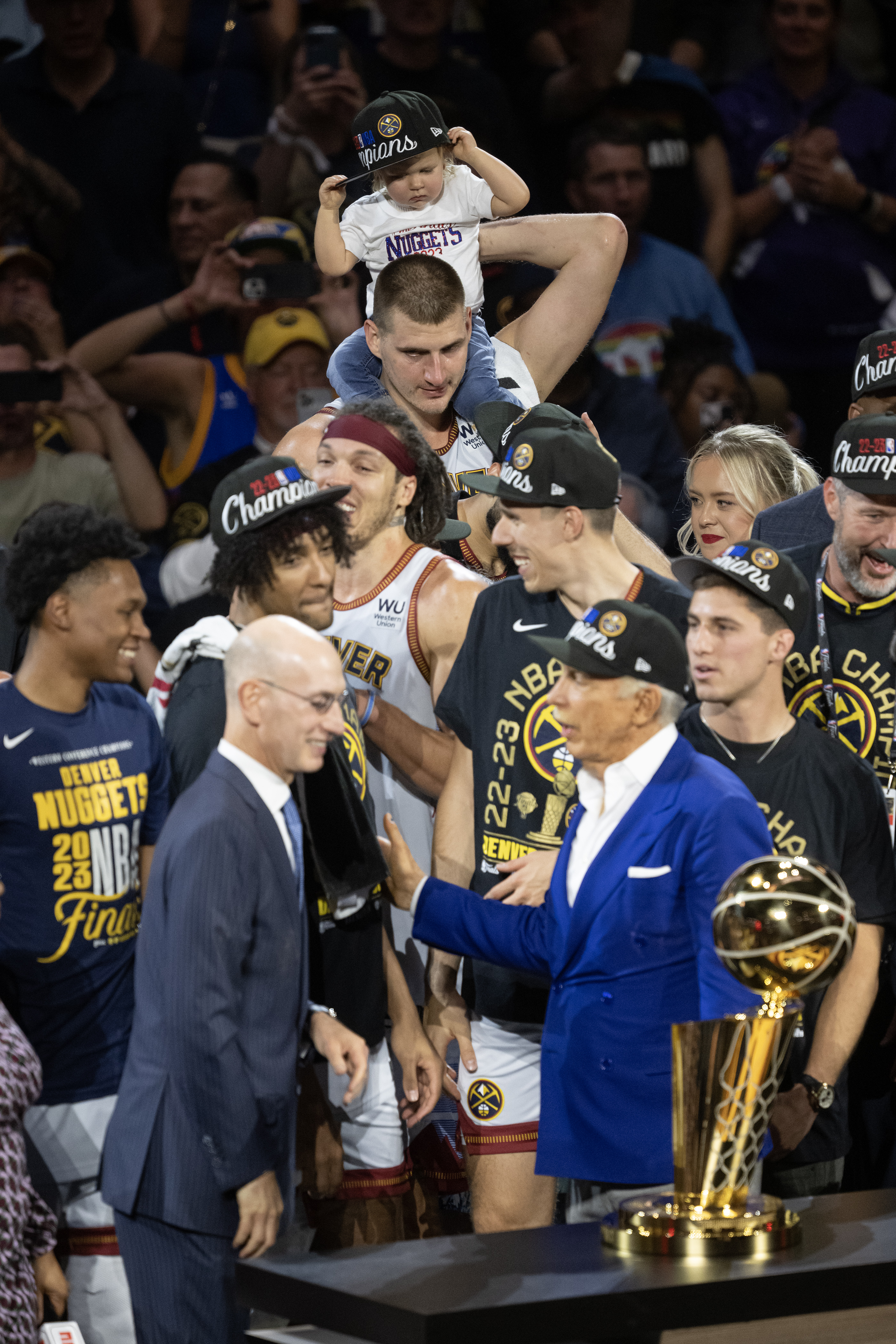 Denver Nuggets center Nikola Jokic (15) hold his daughter Ognjena at the back of the risers as NBA commissioner Adam Silver, left, presents the Larry O’Brien Championship Trophy to head coach Michael Malone after a 94-89 win over the Miami Heat in Game 5 of the NBA Finals on Monday, June 12, 2023, at Ball Arena in Denver. (Timothy Hurst/Denver Gazette) (TimHursttim.hurst@gazette.comhttps://secure.gravatar.com/avatar/aca82bd62b4ee425c598527cd6faa1b1?d=mm&r=g)